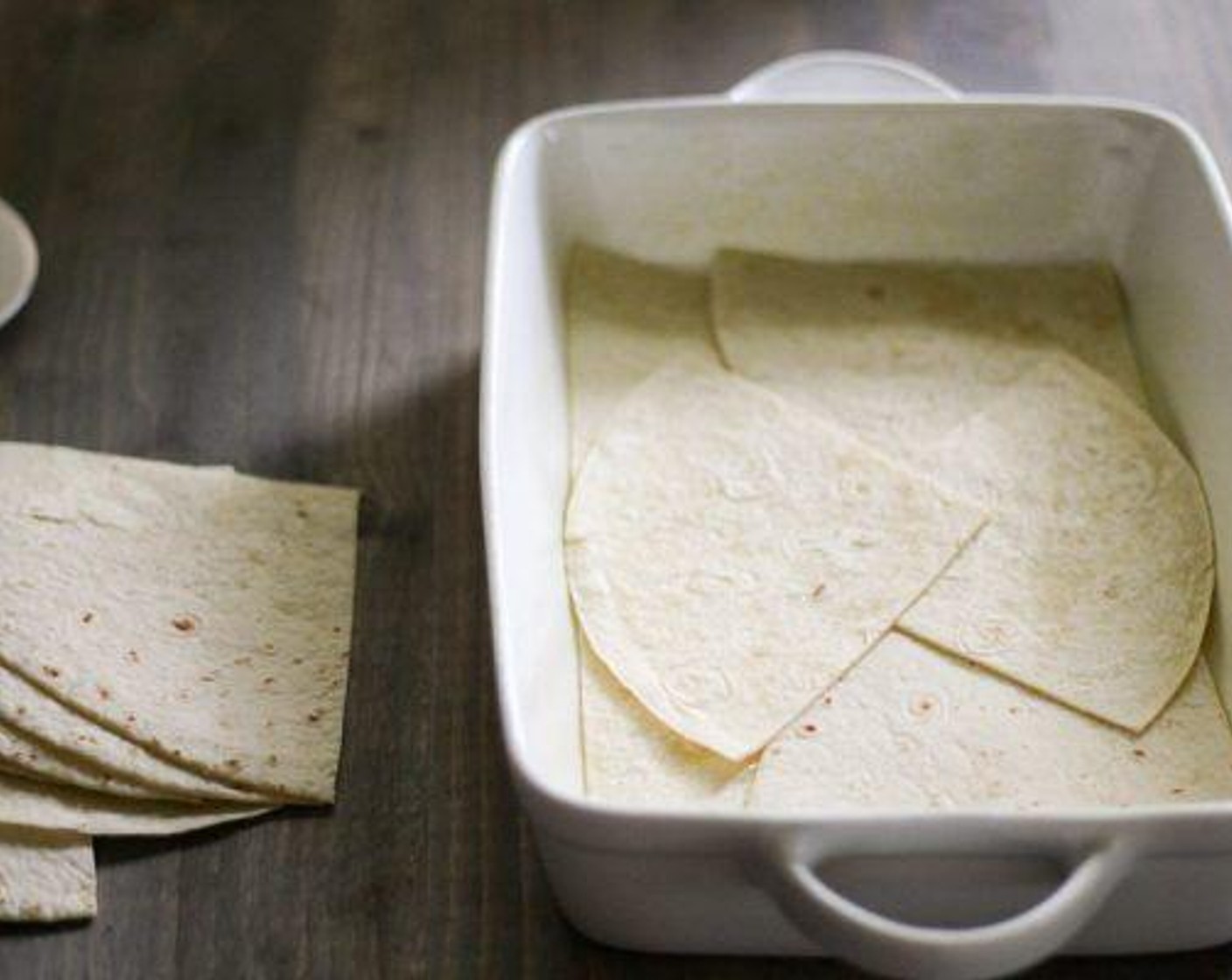 step 3 Cut Large Flour Tortillas (2) into halves or quarters and create a layer in the bottom of the baking dish.