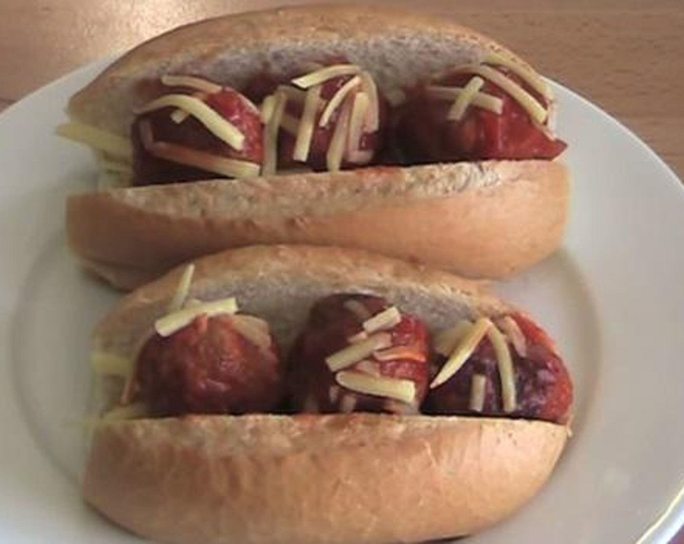 step 4 Into the Bread Rolls (4), add the Cheddar Cheese (to taste) and the meat ball mixture. Serve and enjoy!