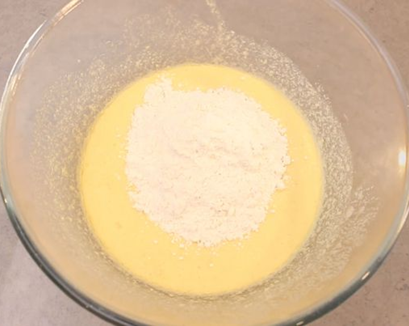 step 2 Into a large bowl add the Caster Sugar (1/2 cup) and Eggs (3) and then whisk until pale and creamy. Then add the Butter (1/4 cup) and whisk that in, now add the Vanilla Extract (1 tsp) and Self-Rising Flour (1/3 cup). Incorporate the flour well until you have a smooth cake batter consistency and then pour the batter into a greased pie dish.