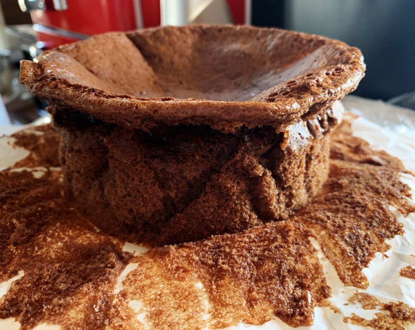 step 8 Then using the parchment paper, lift up the cake out of the pan, and gently open up the sides of the paper. In this phase the cake will nattily go down a bit and it might crack a bit on the top. Do not worry, this is totally normal!