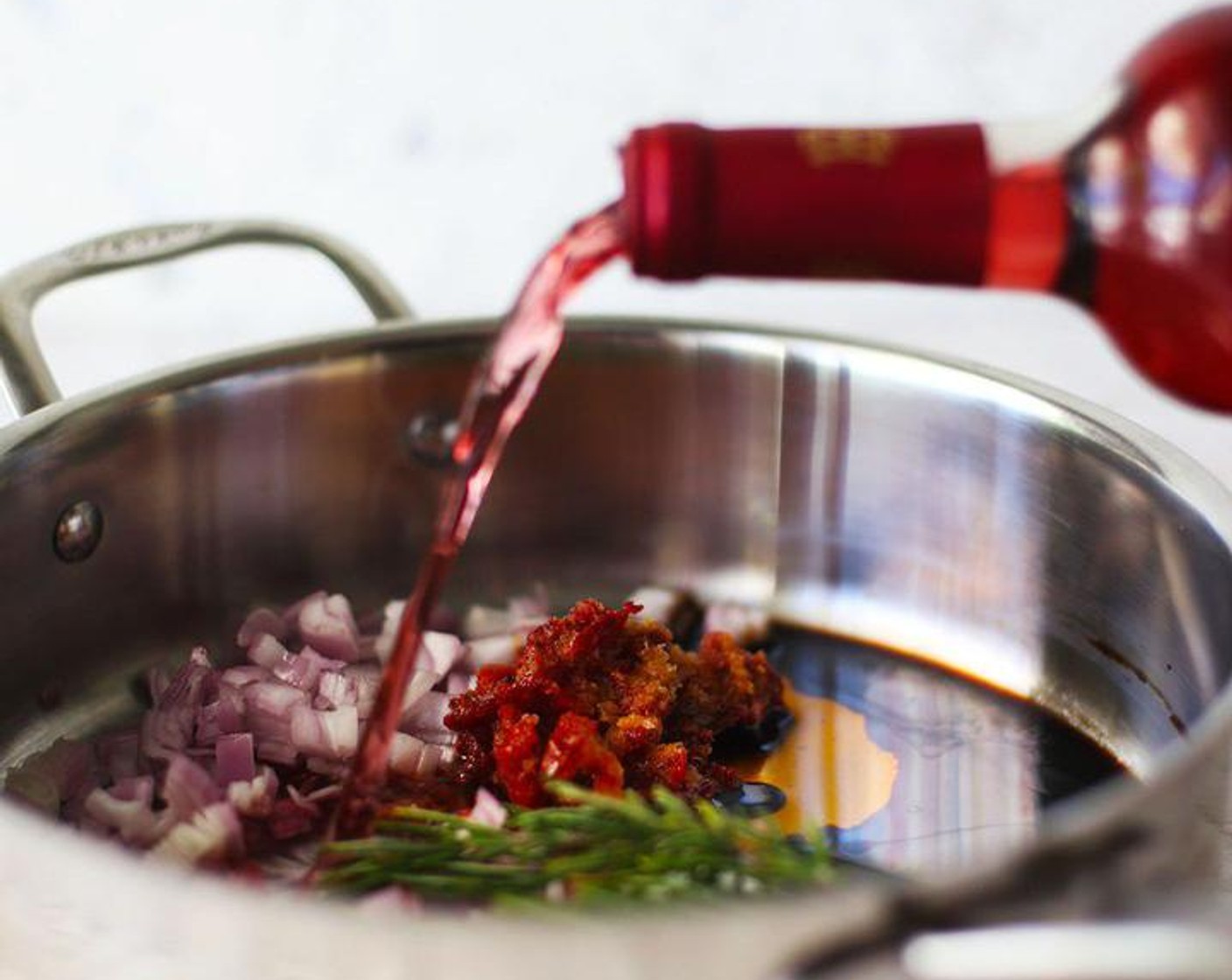 step 1 Chop Shallot (1) and place in a large skillet with Fresh Rosemary (3 sprigs), Sun-Dried Tomatoes (1/4 cup), Rosé Wine (3 cups), and Balsamic Vinegar (1 Tbsp). Cook over medium heat and bring to a simmer. Cook down the wine until reduced by half.