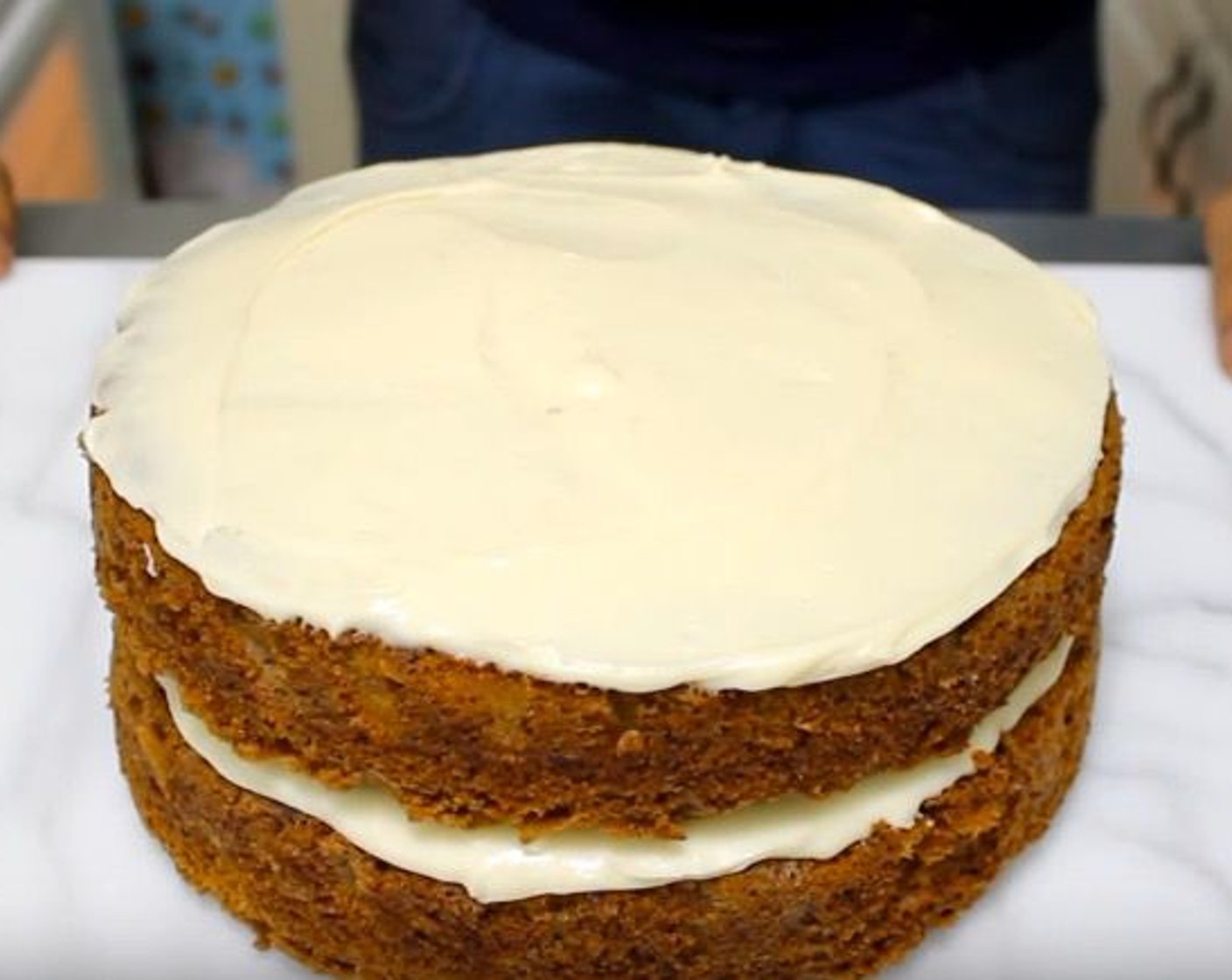 step 10 Spread cream cheese frosting onto the flat side of the first cake. Place the other cake on top and spread frosting over.