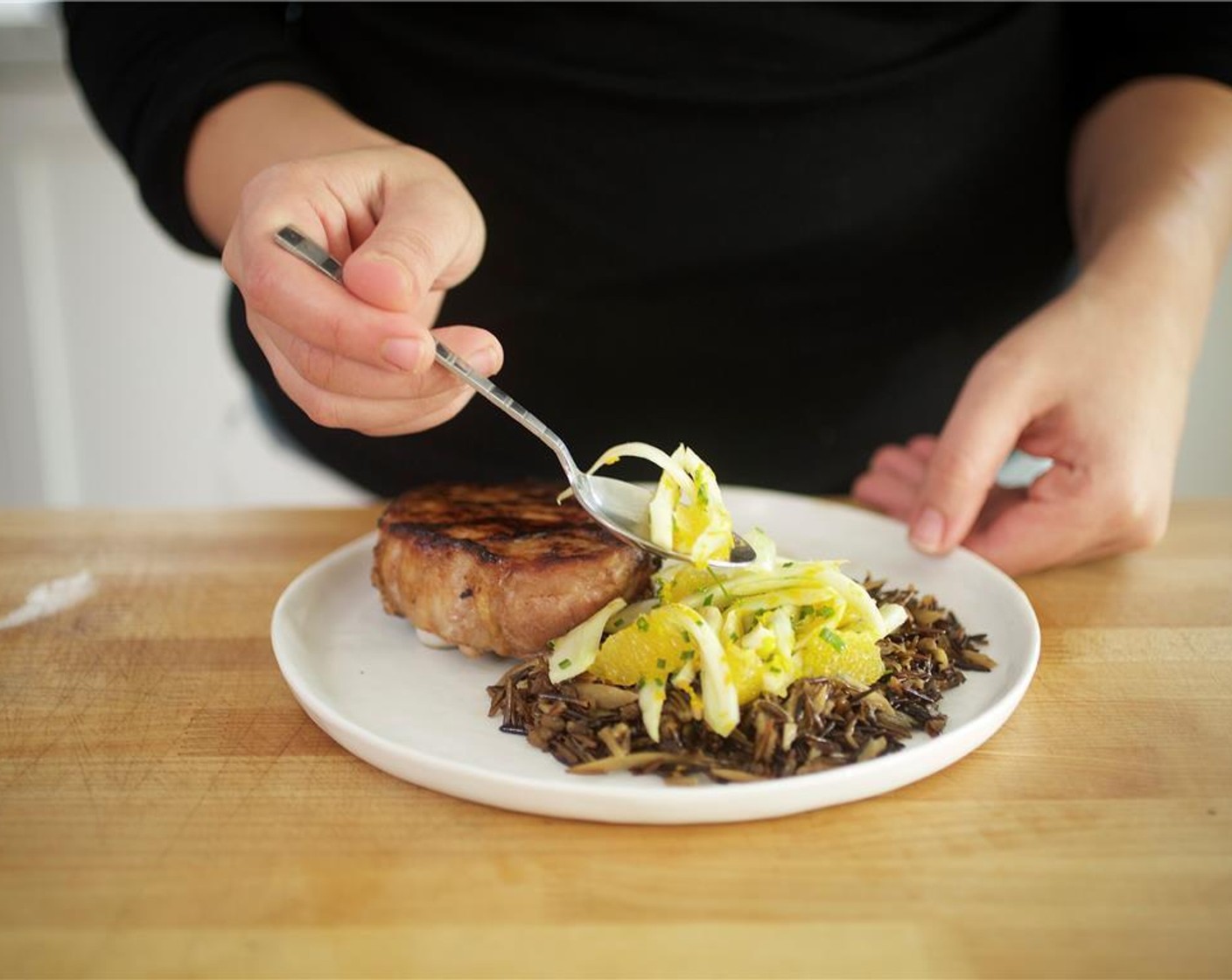 step 18 Place wild rice on two plates and place pork chop directly on top. Place fennel salad on top of the rice.