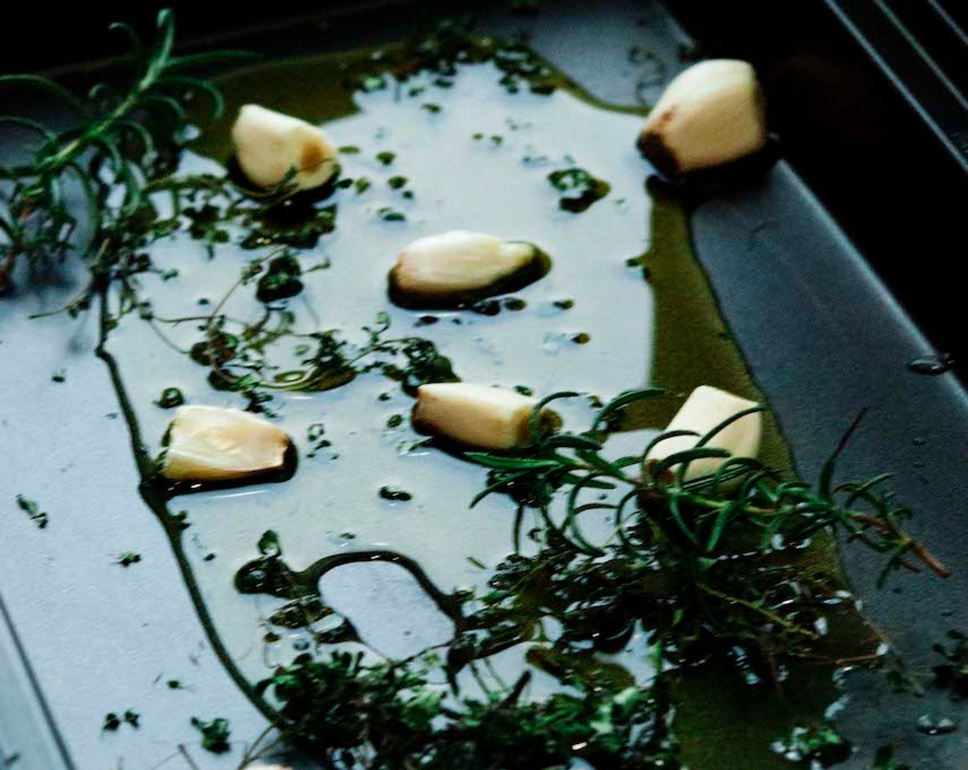 step 3 On a baking tray, sprinkle Olive Oil (3 Tbsp), Garlic (1 bulb), and Fresh Rosemary (to taste).