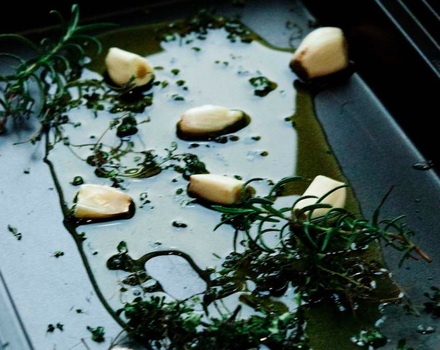 step 3 On a baking tray, sprinkle Extra-Virgin Olive Oil (3 Tbsp), Garlic (1 bulb), and Fresh Rosemary (to taste).