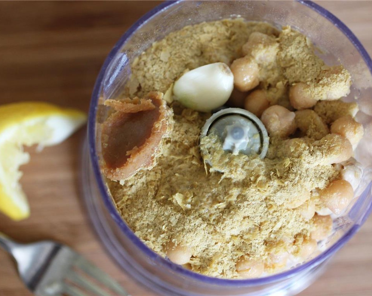 step 3 Combine the soaked Cashew Nuts,Lemon (1/4), Garlic (1 clove), Canned Chickpeas (1/3 cup), Nutritional Yeast (1/4 cup), and White Miso Paste (1/2 Tbsp) in a food processor.