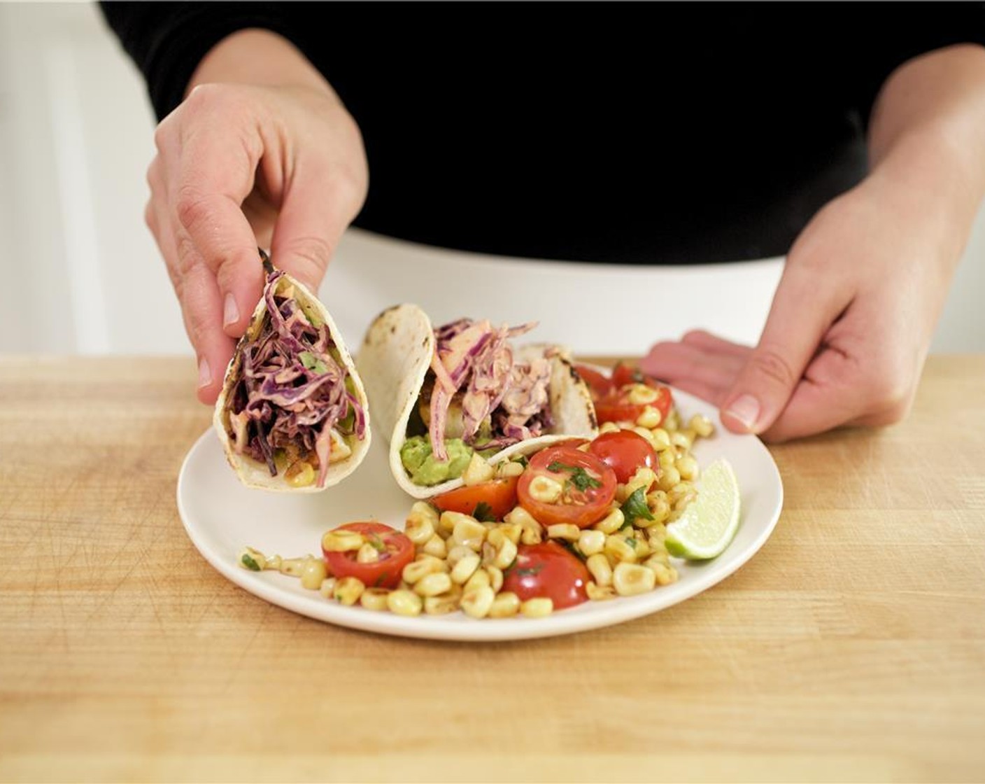 step 18 Place two tortillas side by side on each plate with sides touching, facing upwards. Spread smashed avocado on tortilla. Place mahi mahi fillets onto each tortilla in a single line topped with cabbage mixture and remaining cilantro.