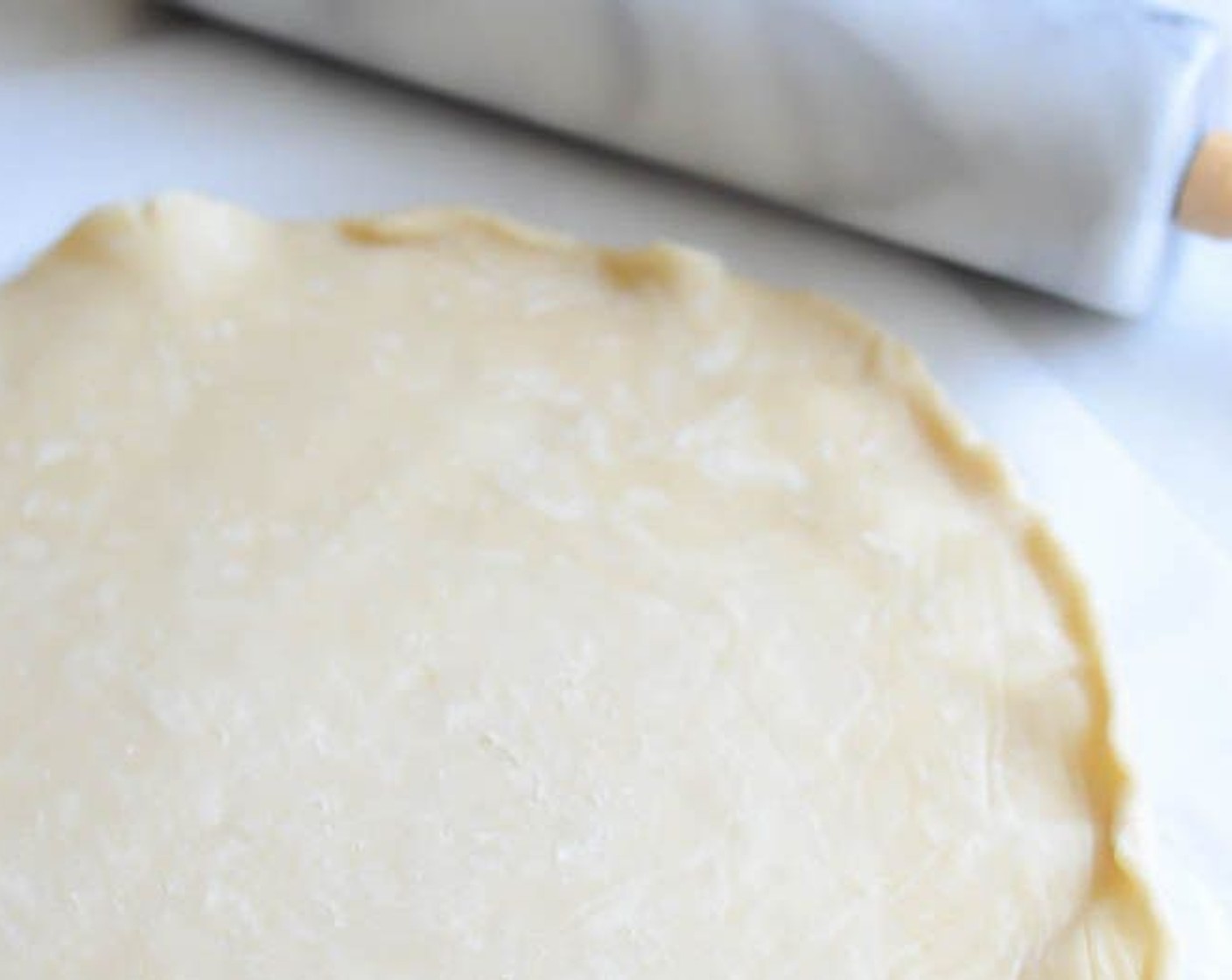 step 2 Place Frozen Shortcrust Pastry (1) between two pieces of parchment paper and roll into a circle about 16-inches in diameter and 1/4-inch thick.