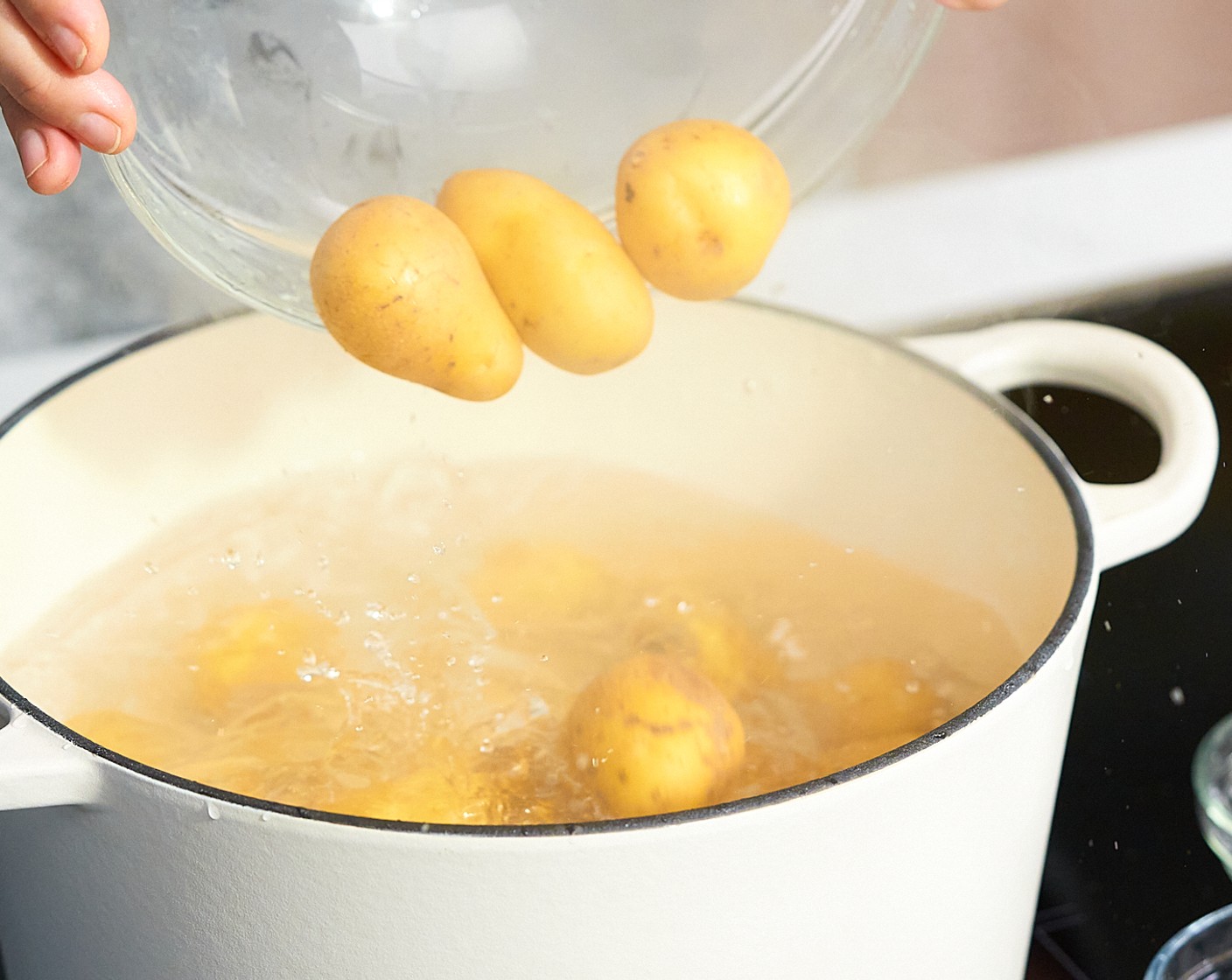 step 2 Einen Topf mit Wasser zum Kochen bringen, die Neue Kartoffeln (6 Tassen) zusammen mit dem Natron (1/2 EL) und dem Salz (1/2 EL) hinzugeben und für 10–15 Minuten weich kochen.