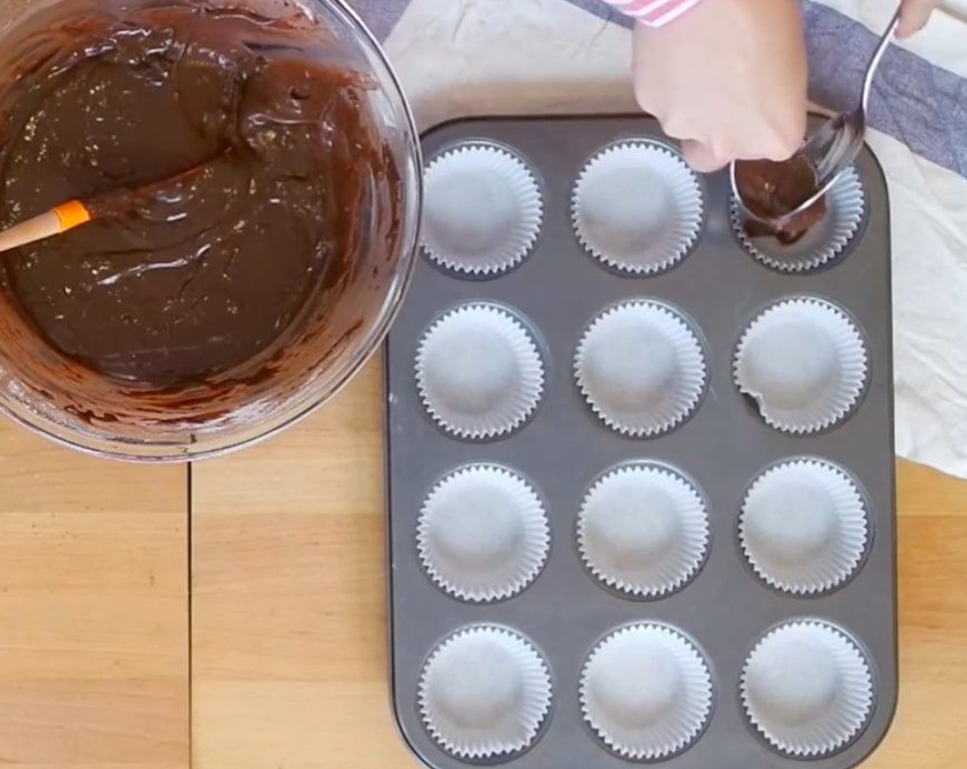step 9 Transfer about a tablespoon of batter onto your muffins pan with liners. Then, dollop Nutella® (1/2 cup) spread using a teaspoon in the middle. Cover it with another tablespoon worth of cake batter.
