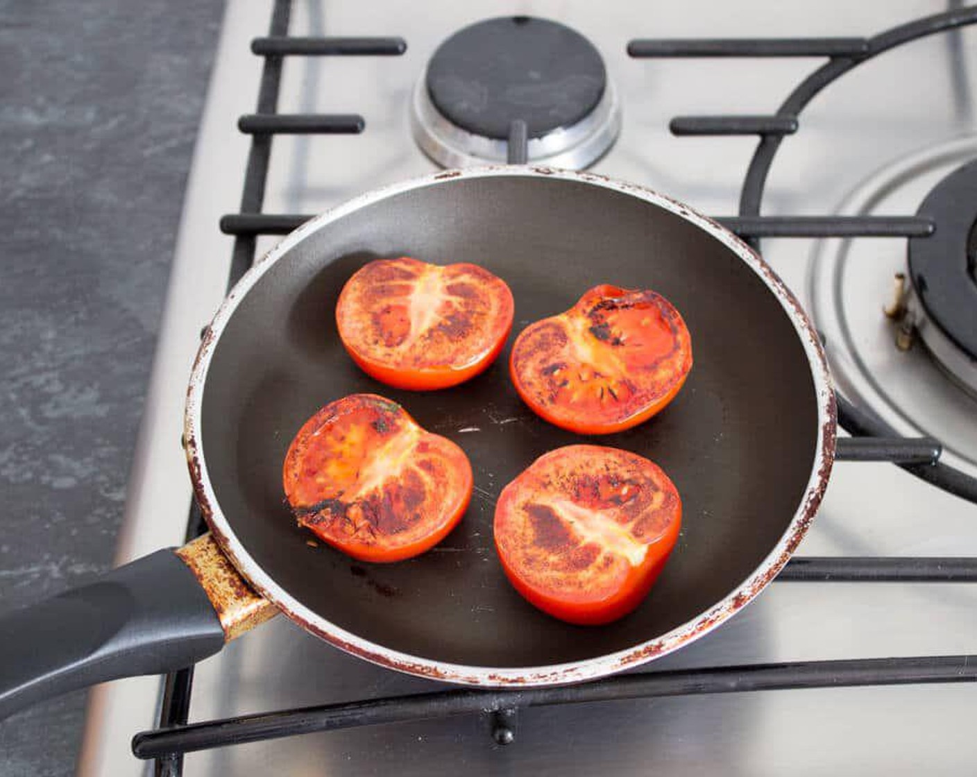 step 1 In a small frying pan (mine was about 8''/20 cm) heat Olive Oil (1 tsp) over a low heat then add the sliced Tomatoes (2) face down. Fry for about 5-10 minutes until softened then flip them over and cook for 3-4 minutes more.
