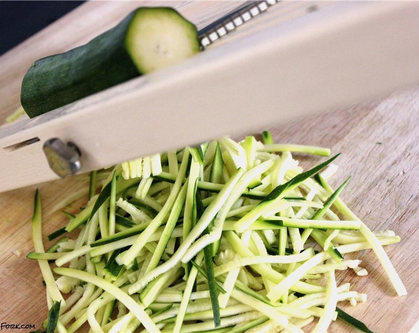 step 1 First, fill a small pot with hot water and place over high heat. While waiting for water to boil, cut the ends off the Zucchini (2) and cut in half lengthwise. Very carefully, grate on a mandoline with the julienne attachment. Set aside.