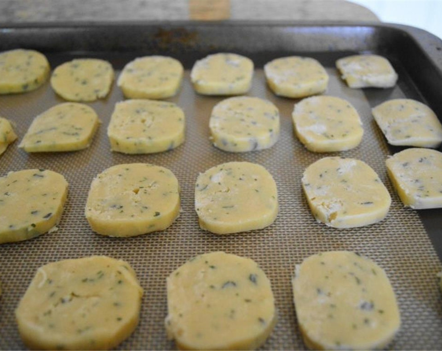 step 6 Take the dough out and slice it into about 1/2 inch slices to turn it into pretty little crackers. Spread them out evenly on the sheets. There should be a yield of about 35-40 crackers.