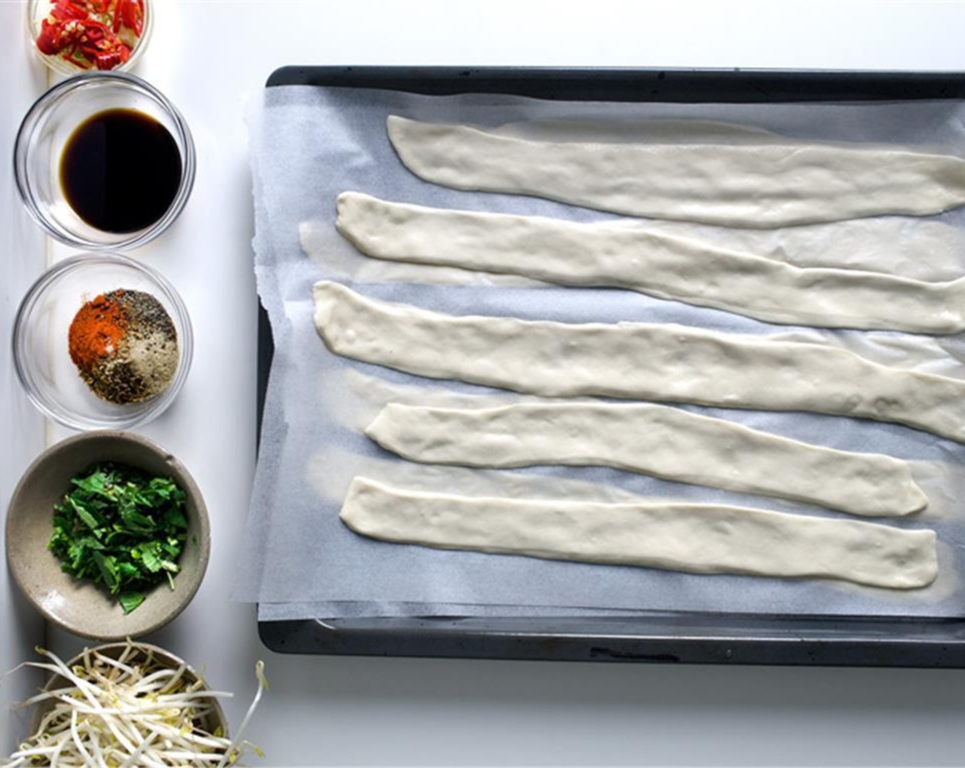 step 18 Lay the noodle flat, without any foldings, on the parchment-lined baking-sheet.  Repeat with the rest (lay a new parchment over the top once you run out of space).