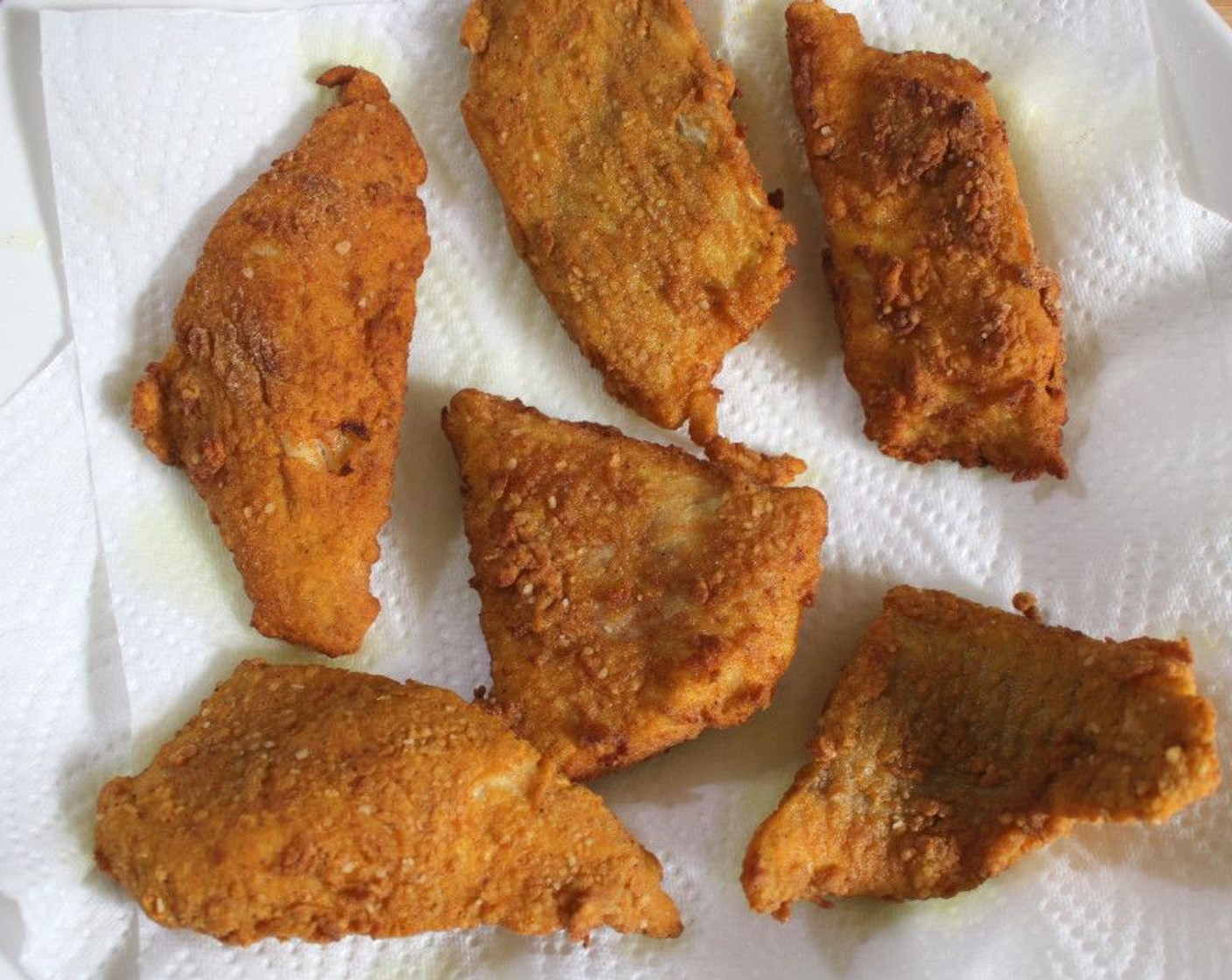 step 6 Fry the fish in batches until nearly cooked through, then remove and place on a plate covered with paper towels. The carry-over heat will finish cooking the fish.