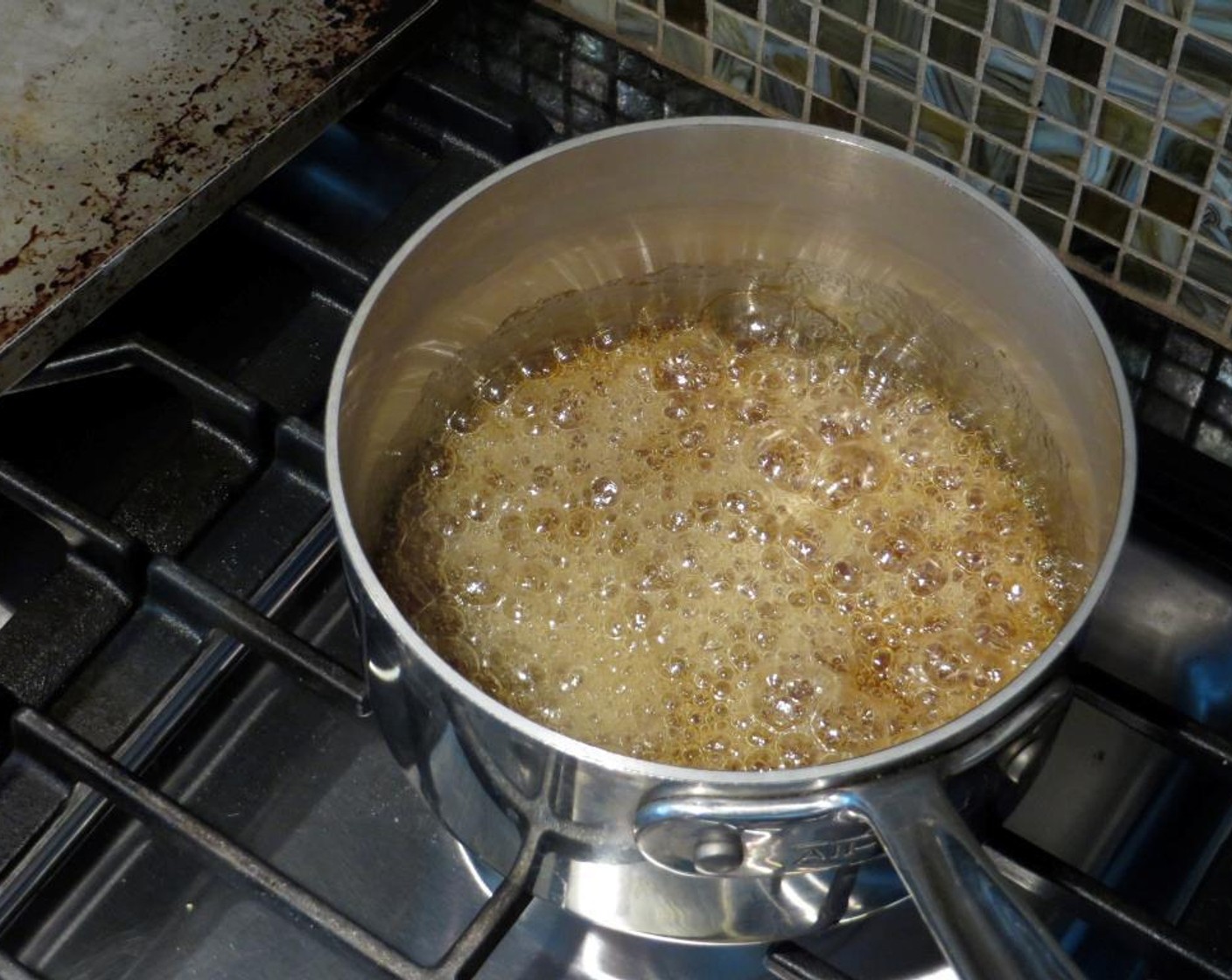 step 5 Bring mixture to a rolling boil and watching the sugar mixture deepen in color. It will go from a light corn-syrup color to light brown.