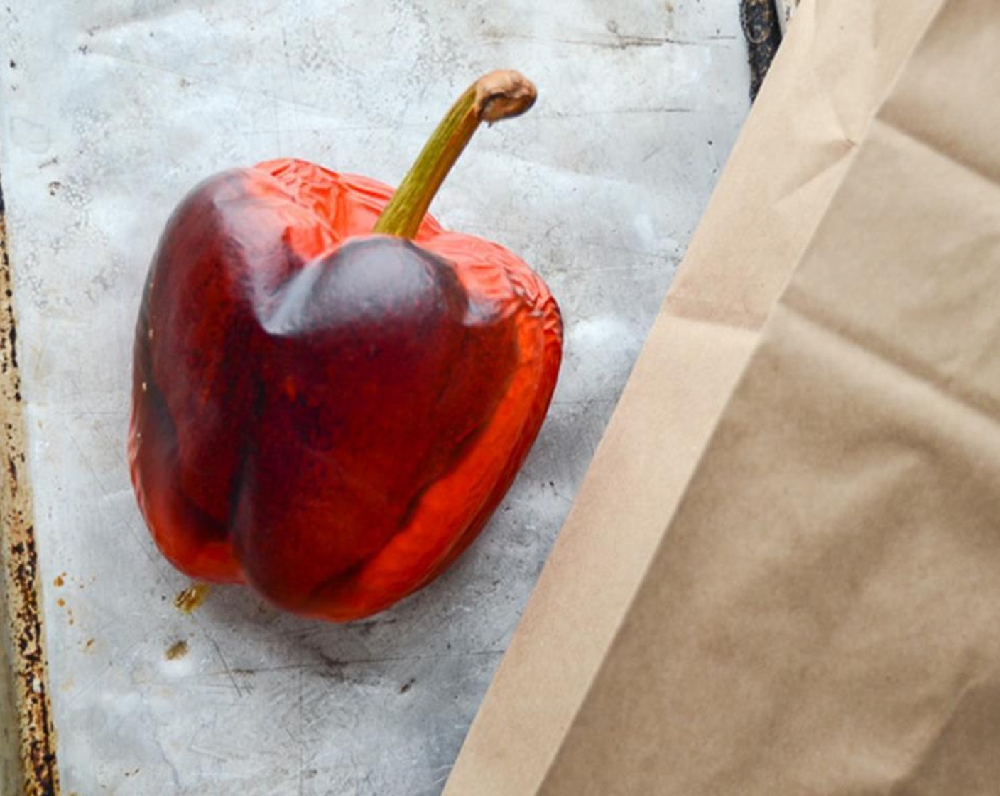 step 1 Preheat oven to 400 degrees F (200 degrees C). Place the whole Red Bell Pepper (1) on a baking sheet and cook for 25 minutes or until skin blackens and flesh is tender.