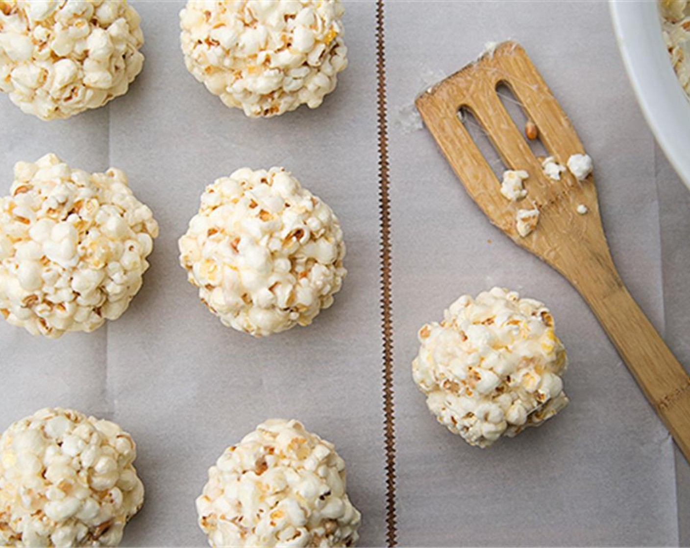 step 4 Grease hands with butter and quickly shape the coated popcorn into balls before it cools.