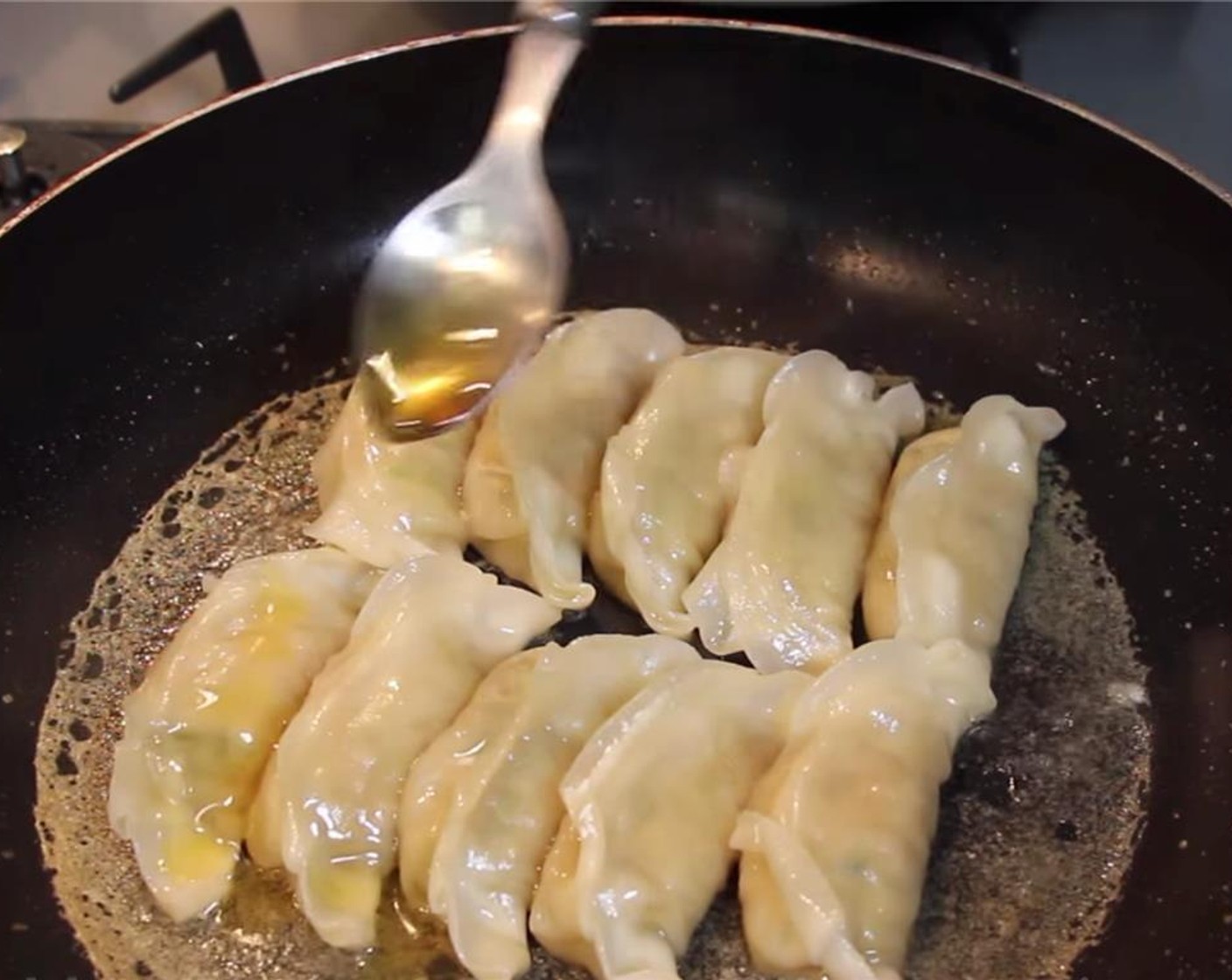 step 15 If you see big bubbles forming, turn the heat to the lowest setting and continue cooking until there is a little water left and add in Sesame Oil (1 Tbsp). Swirl the pan around so the dumplings are evenly coated with sesame oil.