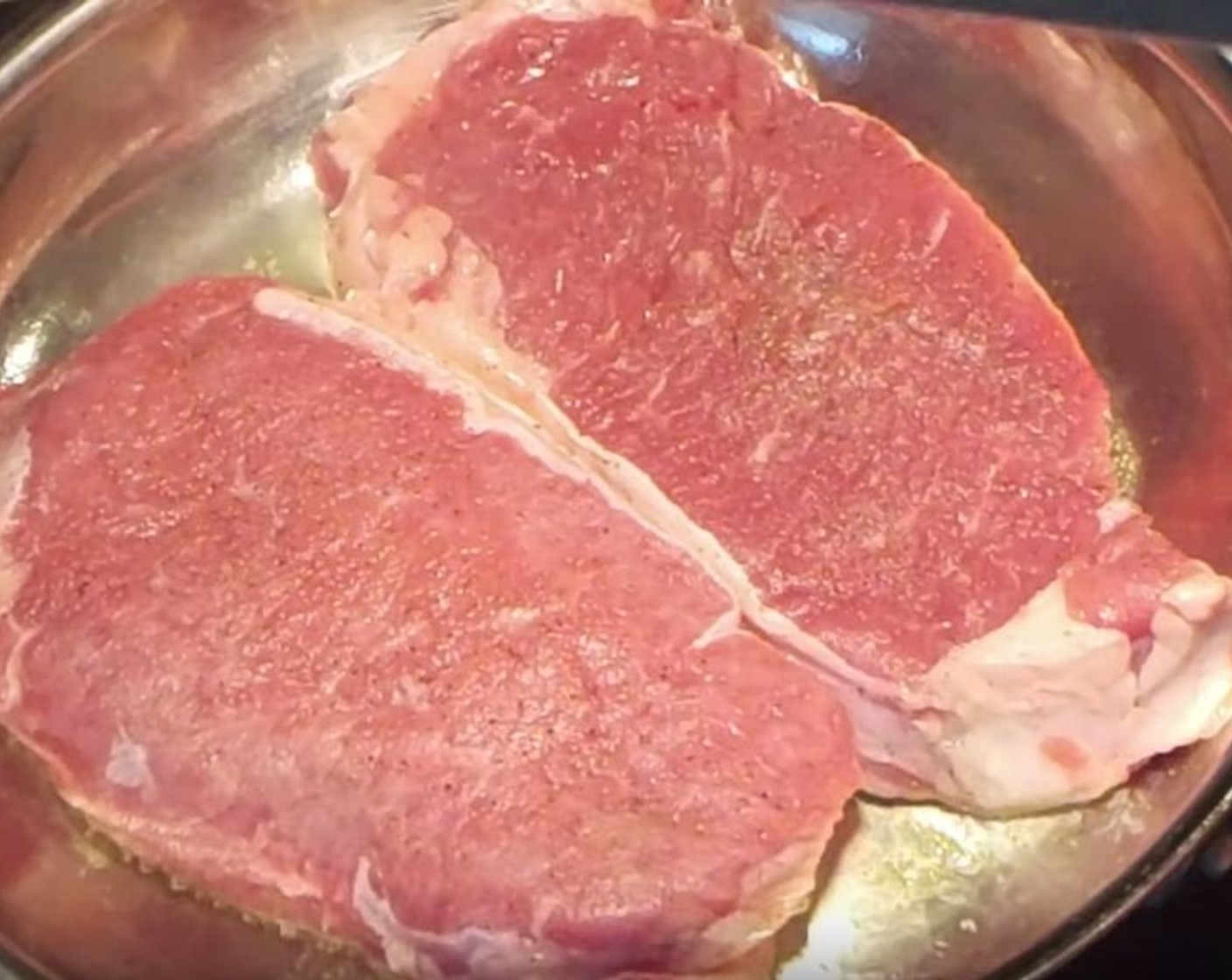 step 7 While they're baking, season each New York Strip Steak (2) with Sea Salt (to taste) and Ground Black Pepper (to taste).