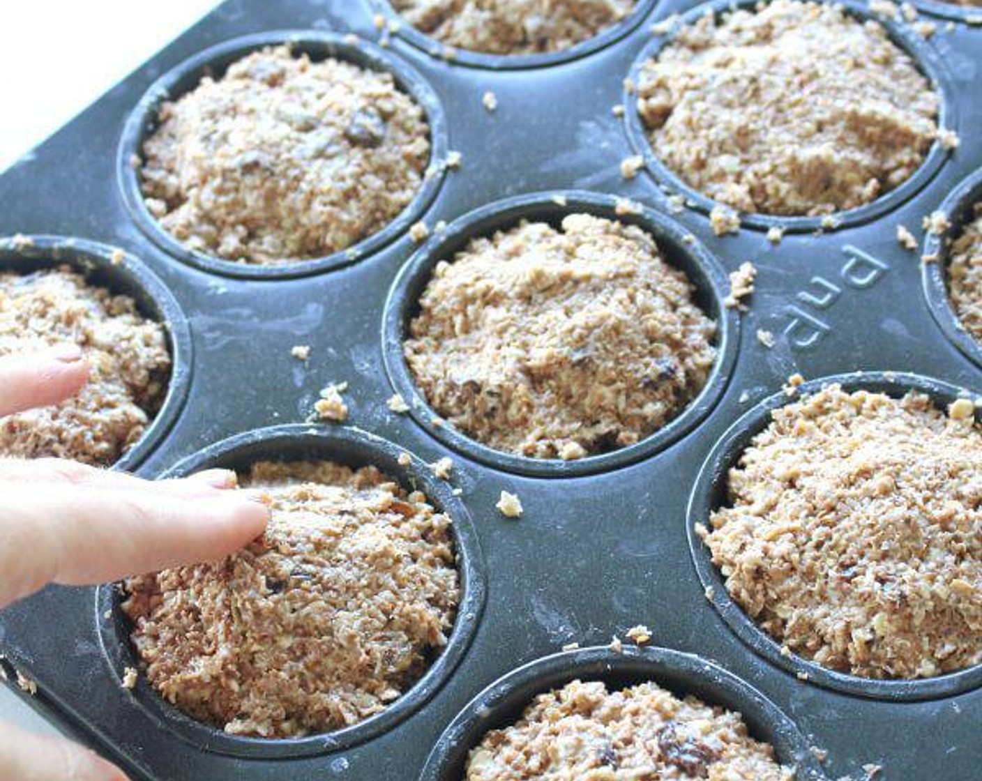 step 5 Pack the mixture into the muffin cups right to the top, and press down with your fingers. Bake for 20 minutes, or until a cake tester comes out clean and the muffins are dark golden brown.