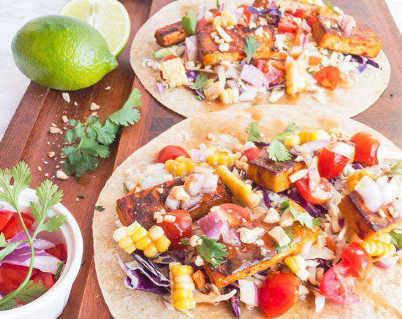 step 4 Cut corn off of the cob, fill Whole Wheat Tortilla (1 pckg) with tofu, corn, Green Cabbage (1 cup), Red Onions (4 Tbsp), Fresh Cilantro (to taste), and Grape Tomatoes (to taste) and top with peanut dressing.