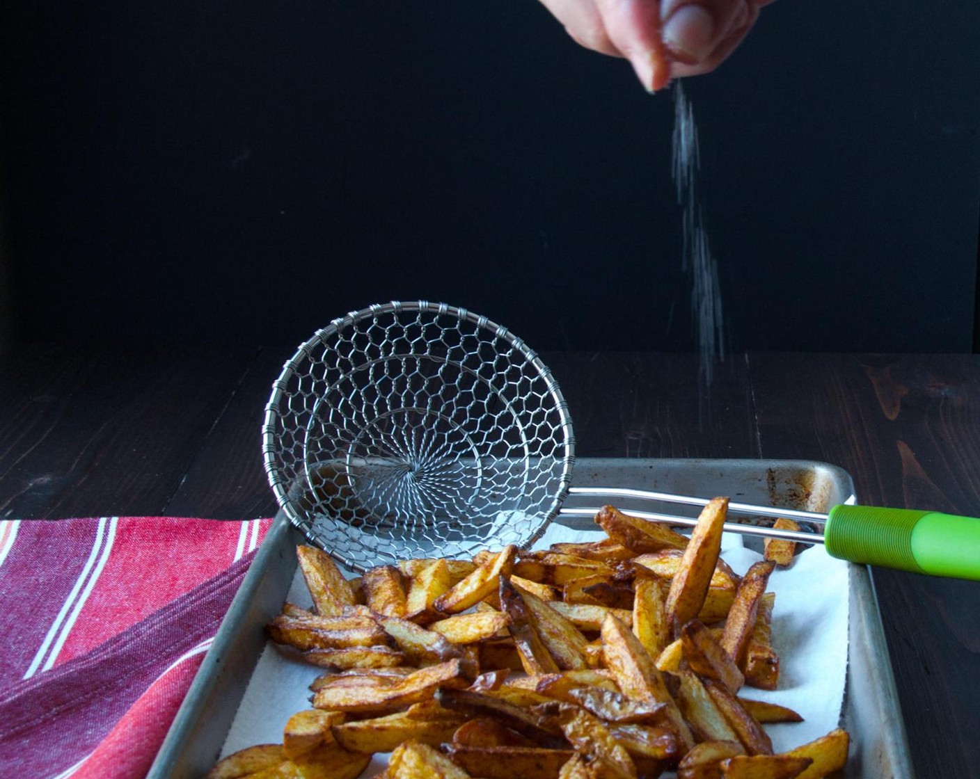 step 7 Use a spider or slotted spoon to scoop out the fries and transfer them to the baking sheet. Immediately sprinkle the fries with Kosher Salt (1/2 tsp).