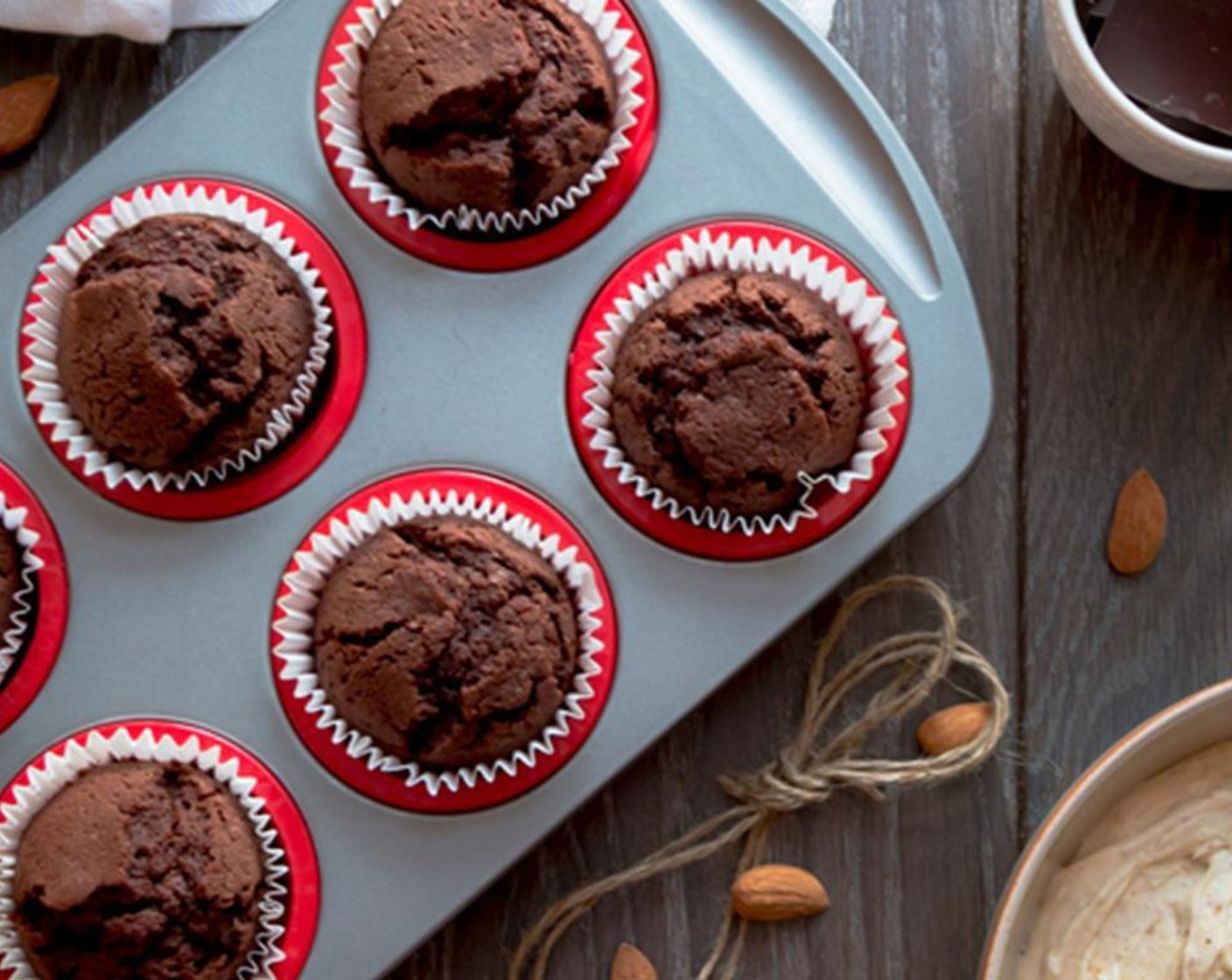 step 5 Fill the muffin tin liners with 2/3 cup of the mixture in each cup. Use an ice cream scoop to obtain same-size cupcakes. Place the muffin tin in the warm oven and bake for 20 minutes or until a skewer comes out clean. Once baked, cool the cupcakes on a cooling rack for frosting.