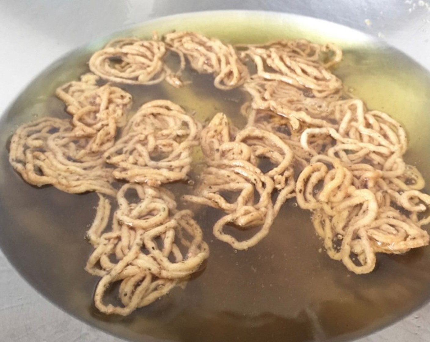 step 16 When the murukku turns crispy golden brown colour on one side and also when bubbles ceases, flip to the other side and cook till done when the bubbles just about disappear.