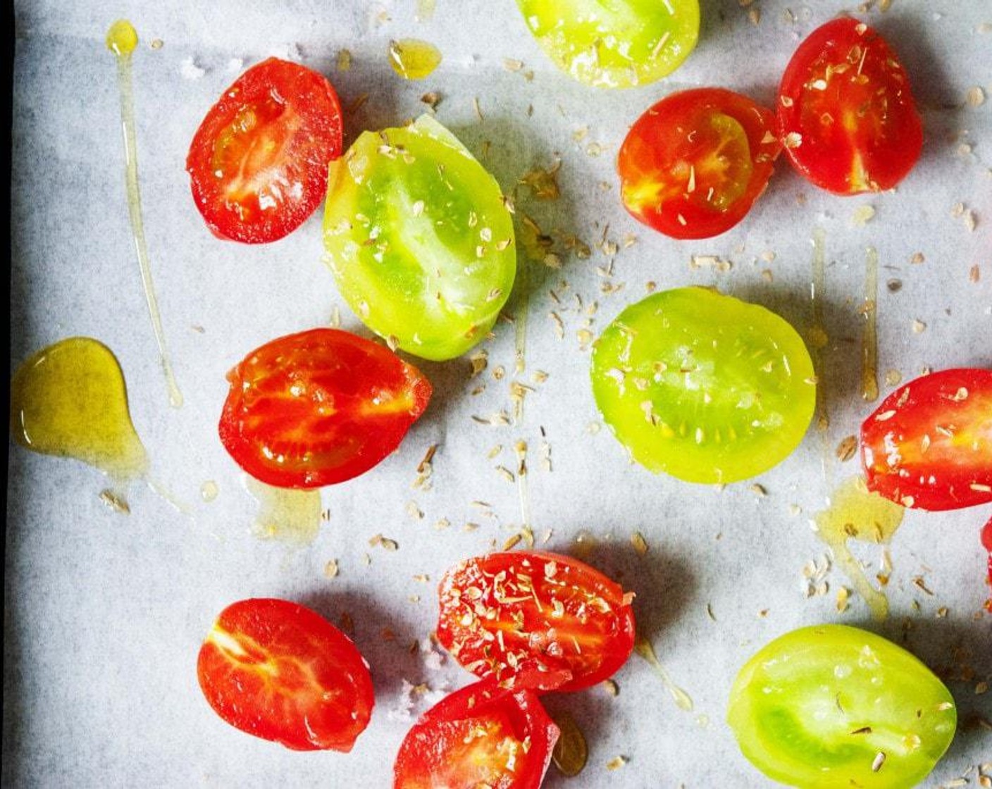 step 2 Start off by preparing the confit Cherry Tomatoes (2 cups). Slice up in half the red and green cherry tomatoes. Place them side up on a baking tray. sprinkle with Salt (to taste), Granulated Sugar (1 Tbsp), Fresh Oregano (1 Tbsp), and 1 tablespoon of the Olive Oil (1 Tbsp).