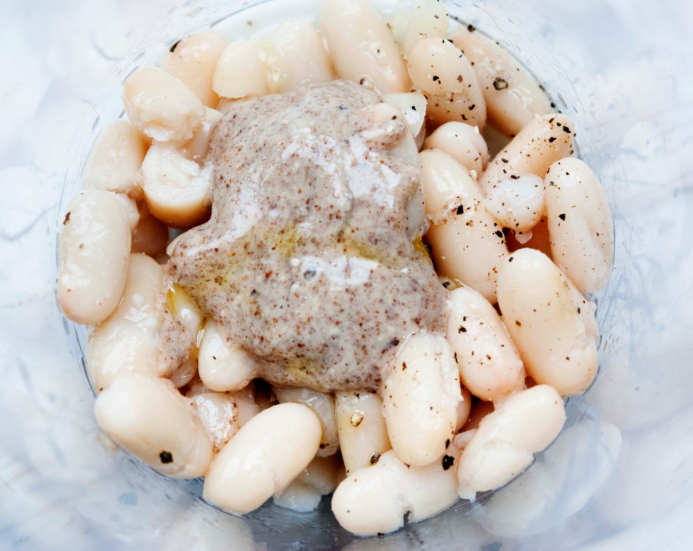 step 1 In a deep glass bowl place the White Beans (1/2 can), Salt (to taste), Ground Black Pepper (to taste), 1 Tbsp of Lemon Juice (1), Almond Butter (1 Tbsp), and Extra-Virgin Olive Oil (1 Tbsp). Using an immersion blender process until creamy.