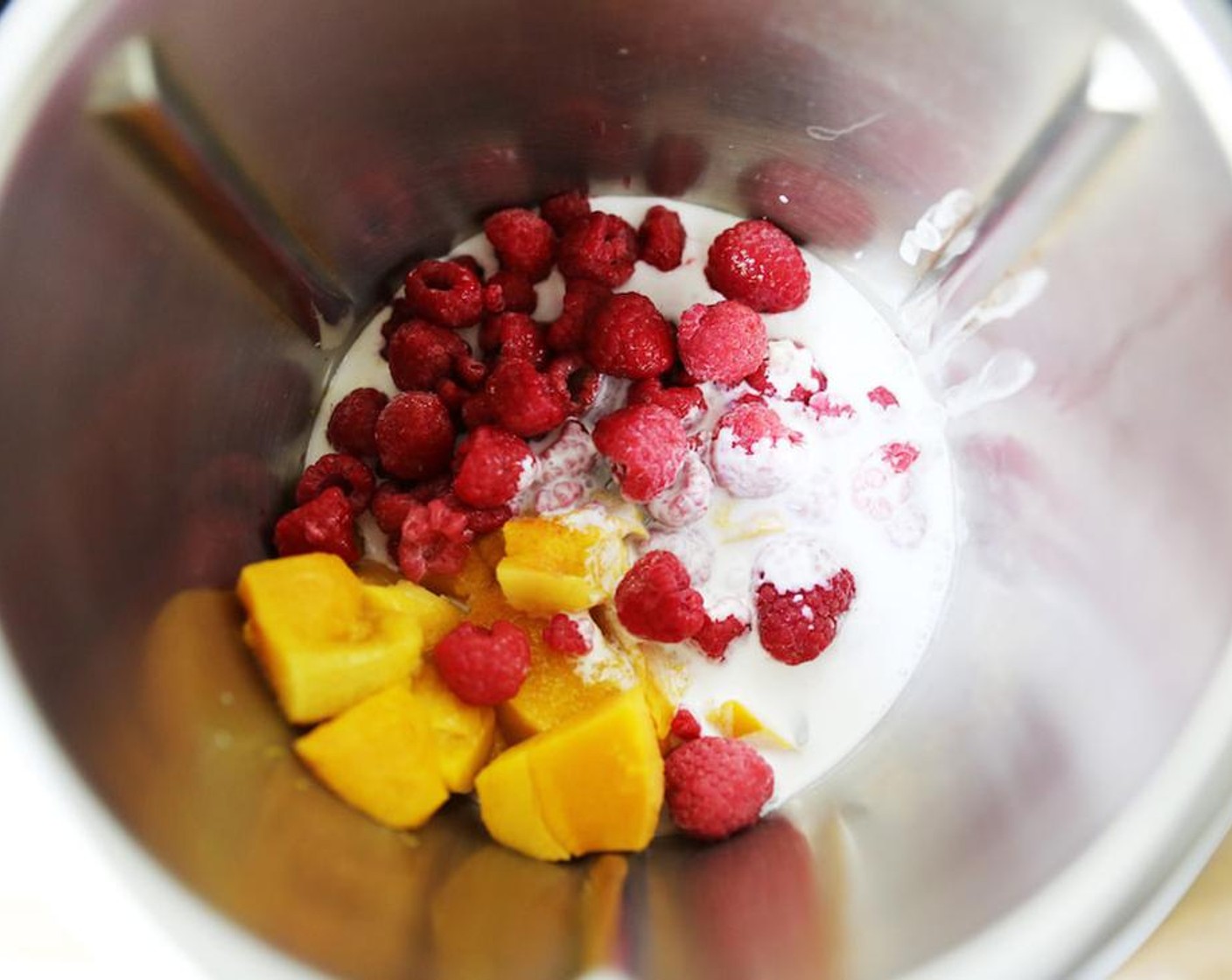 step 2 Blend the Frozen Mangoes (3/4 cup), Frozen Raspberries (1/2 cup) and Coconut Milk (8 oz) on speed 5 for 2 minutes until smooth.