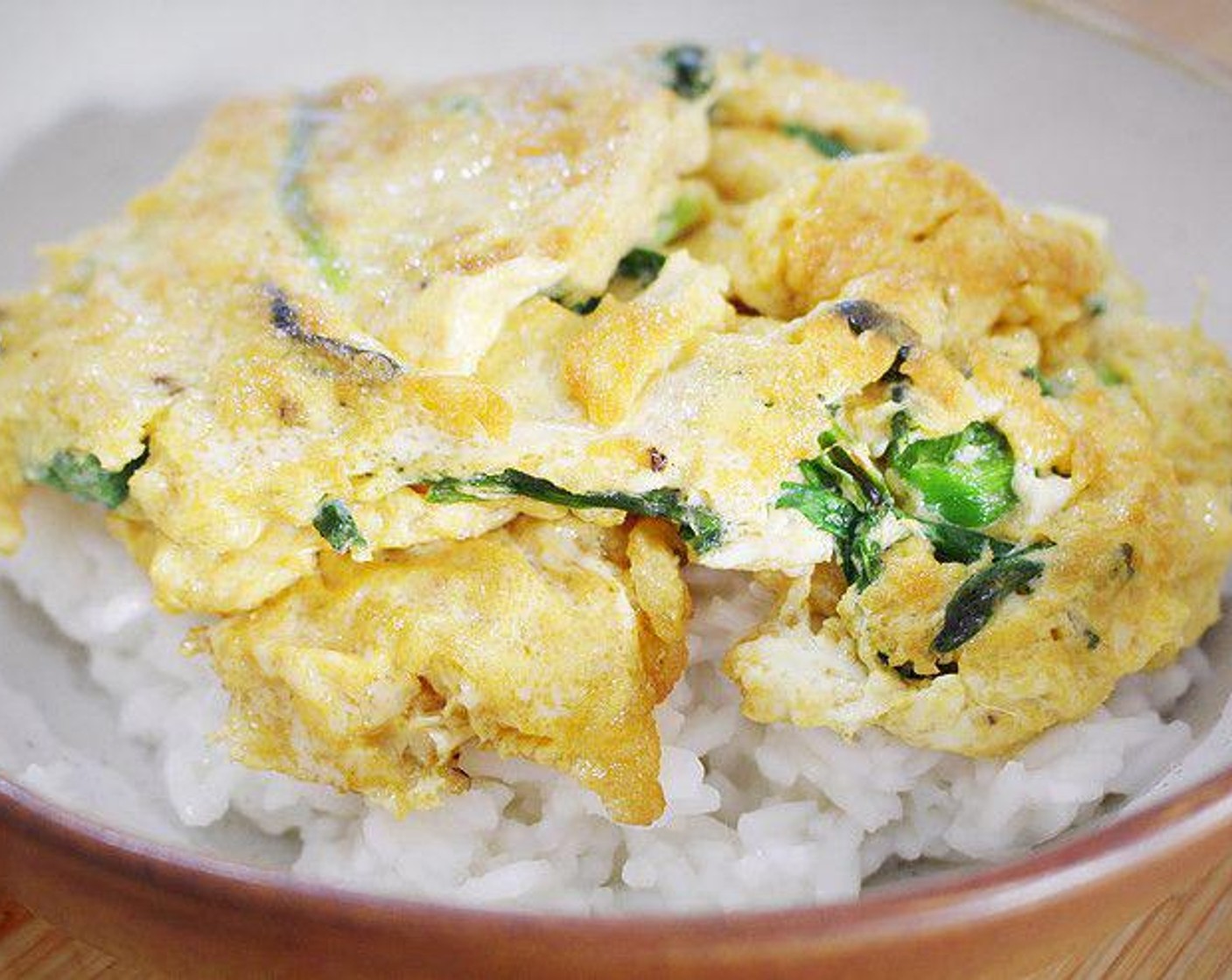 step 4 When the egg is almost cooked, put the cooked Short Grain White Rice (2 1/2 Tbsp) in a serving plate/bowl and transfer the egg with garlic chives over the rice. Serve immediately.