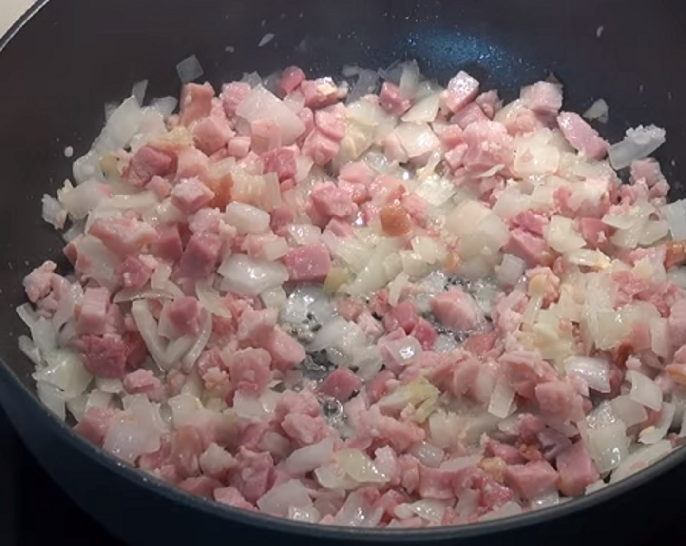 step 2 In a deep fry pan, add a bit of Olive Oil (as needed). Over medium to high heat, add Yellow Onion (1), Garlic (2 cloves), and Bacon (7 oz). Stir for 3-4 minutes or until the onion has softened.