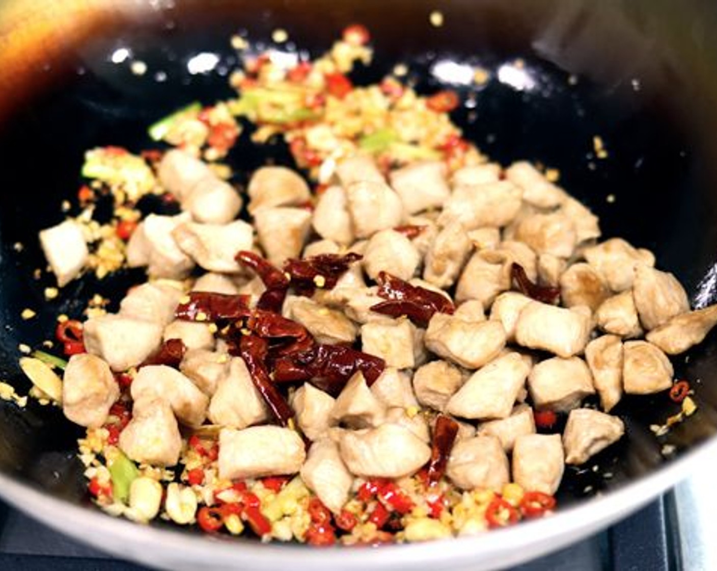 step 12 Add the diced chicken and dried red chilies and toss everything together to combine.