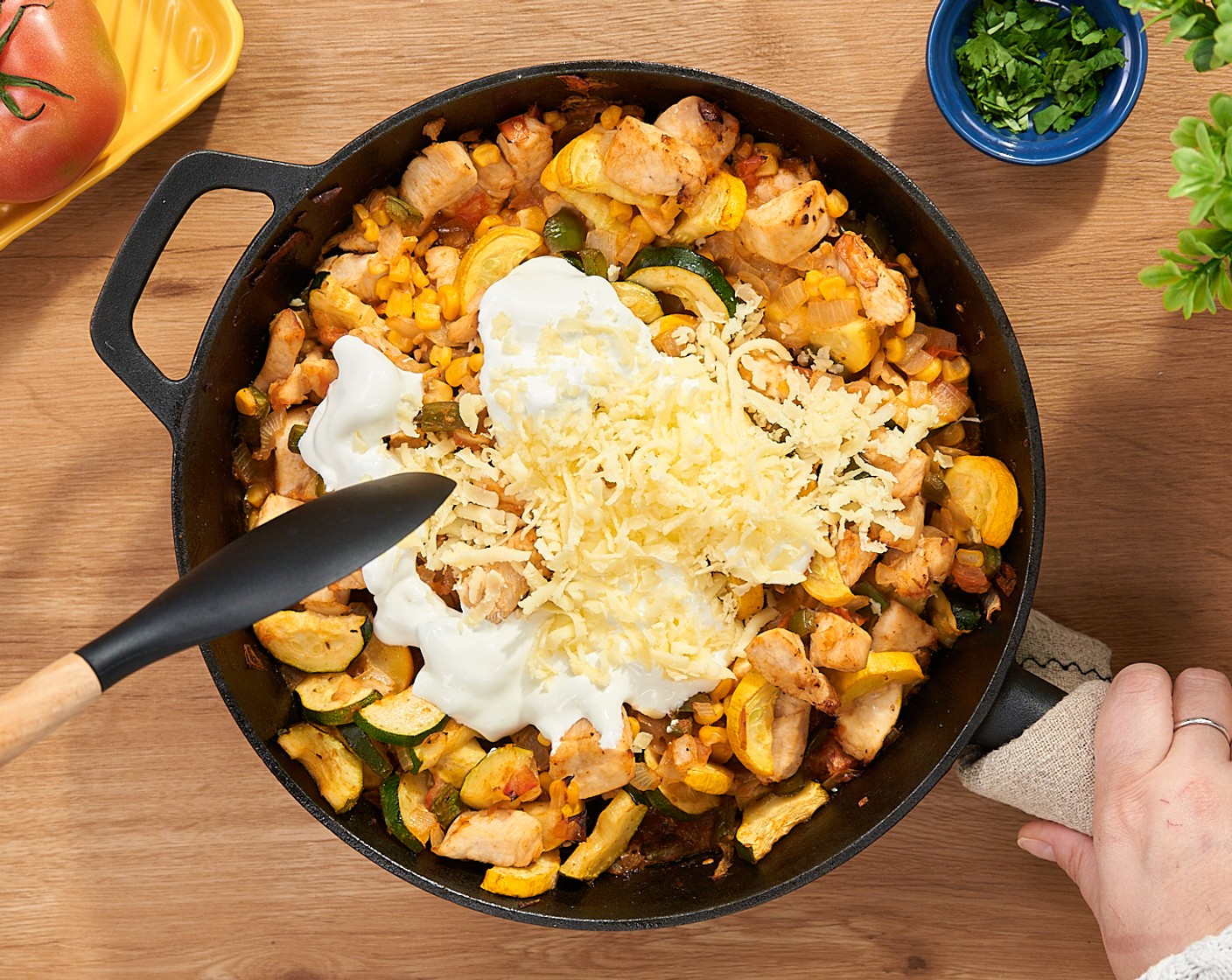 step 7 Danach die Pfanne aus dem Ofen nehmen. Mexikanische Creme (1/2 Ta.) darüber verteilen und mit Mozzarella, gerieben (1/2 Ta.) bestreuen.