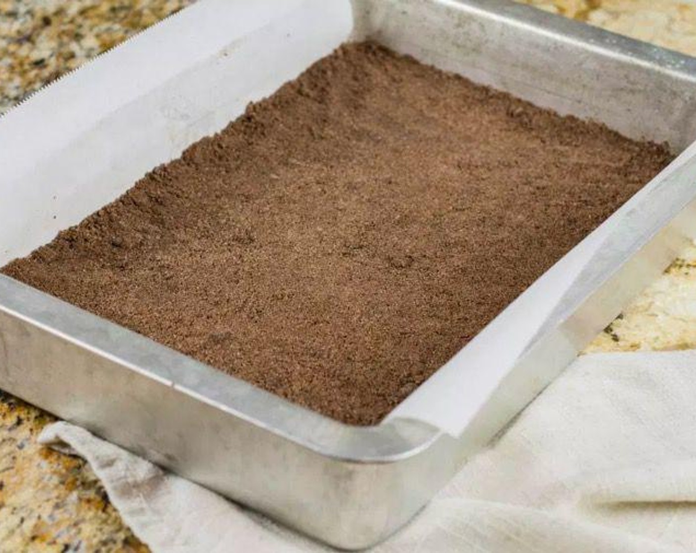 step 5 Spray a 9 by 13-inch pan with nonstick spray. Line the bottom and two sides of the pan with parchment. Press mixture evenly into pan.