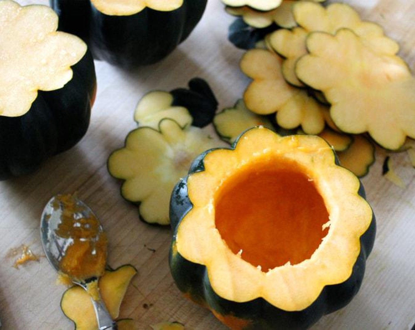 step 2 Turn each Acorn Squash (4) on its side and slice an inch off the stem end, removing and discarding the stem. Using a spoon, scoop out the seeds and flesh. Slice 1/4 inch off the bottom end of the squash so it doesn't wobble. Scoop out the seeds and stringy parts.