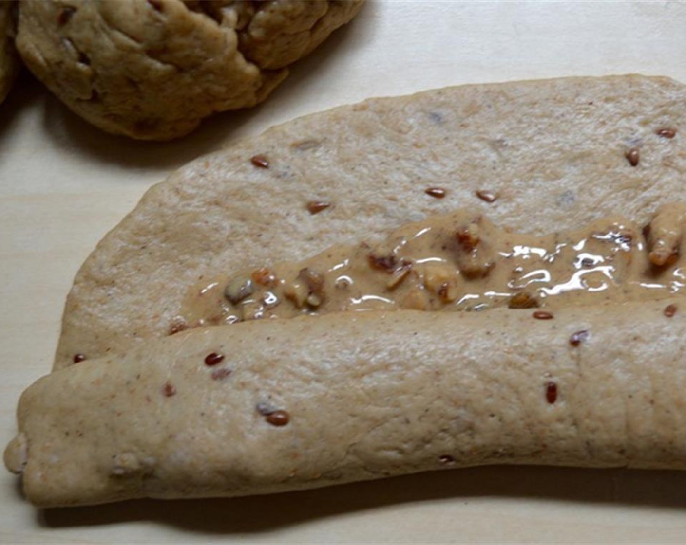 step 6 Roll out each dough piece one by one, and add the Tahini (260 g) and Mixed Dried Fruits and Nuts (120 g) mixture to it, being careful not to spread it out too close to the sides. Then roll the dough into a long cigar shape. Let them sit for 20 minutes.