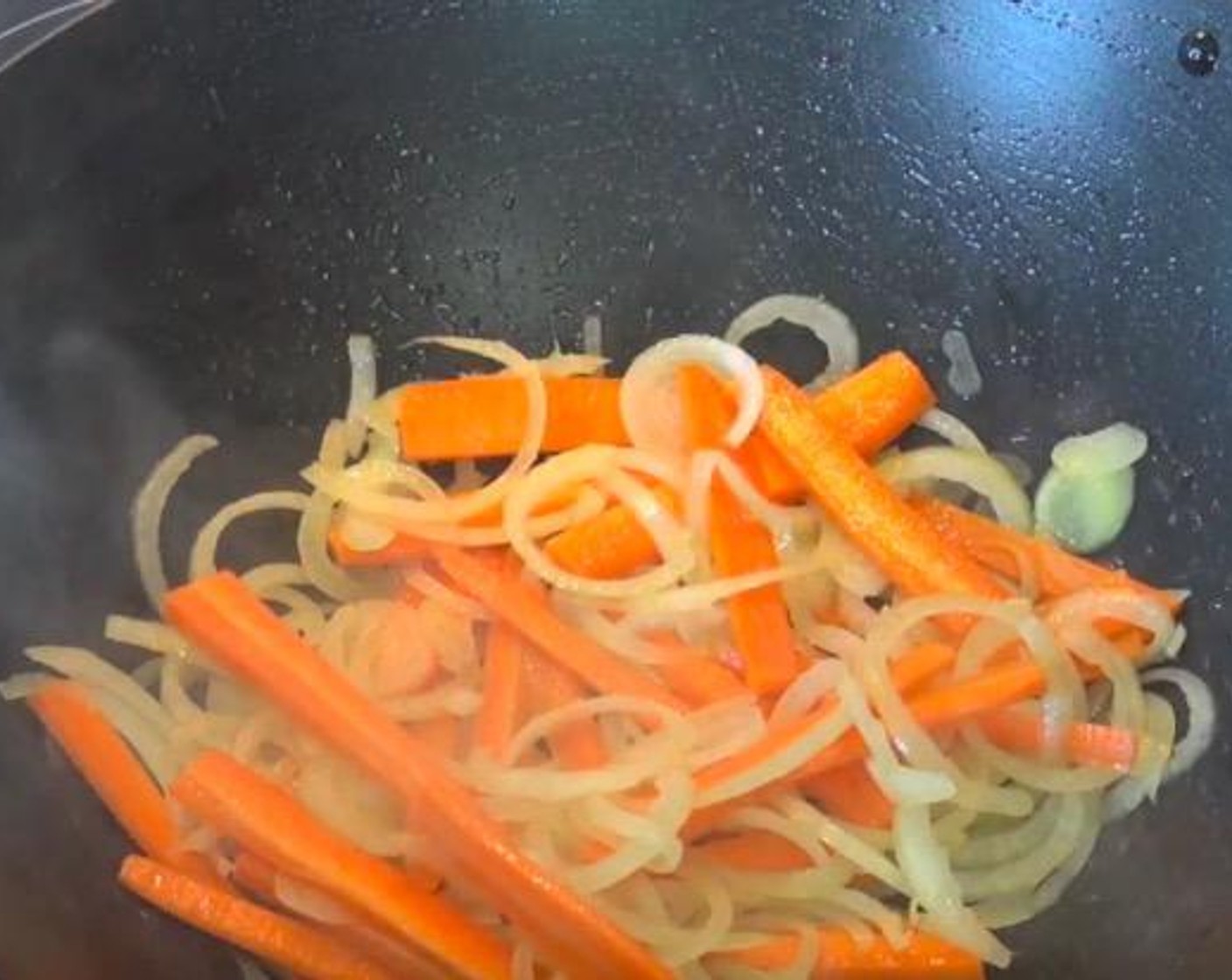 step 4 In the same wok or fry pan, add Yellow Onion (1) and Carrot (1). Stir fry for 2-3 minutes, or until the onion has started to soften.