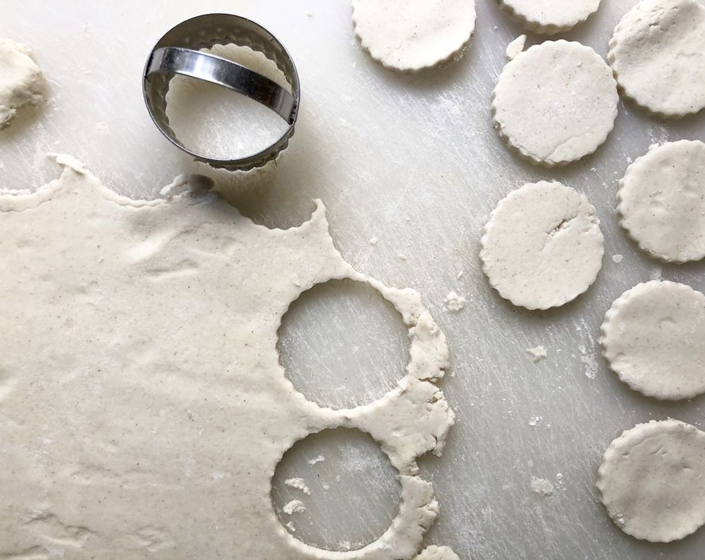 step 10 Finish shaping the crust. Once the dough has chilled, remove one piece from the refrigerator, unwrap it and place it on a lightly floured surface. (Reserve remaining dough for another time.) Sprinkle the top lightly with more flour, and on a lightly floured surface, roll out the dough to about 1/4-inch thick. Using a scalloped-edge round cutter, form as many dough discs as possible.