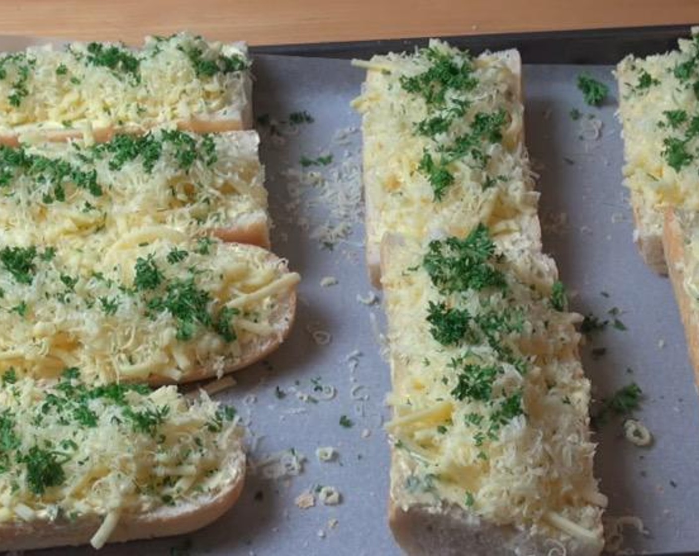 step 3 Spread garlic butter over each slice of bread. Top with Cheddar Cheese (to taste) and Parmesan Cheese (to taste). Garnish with Fresh Parsley (to taste).