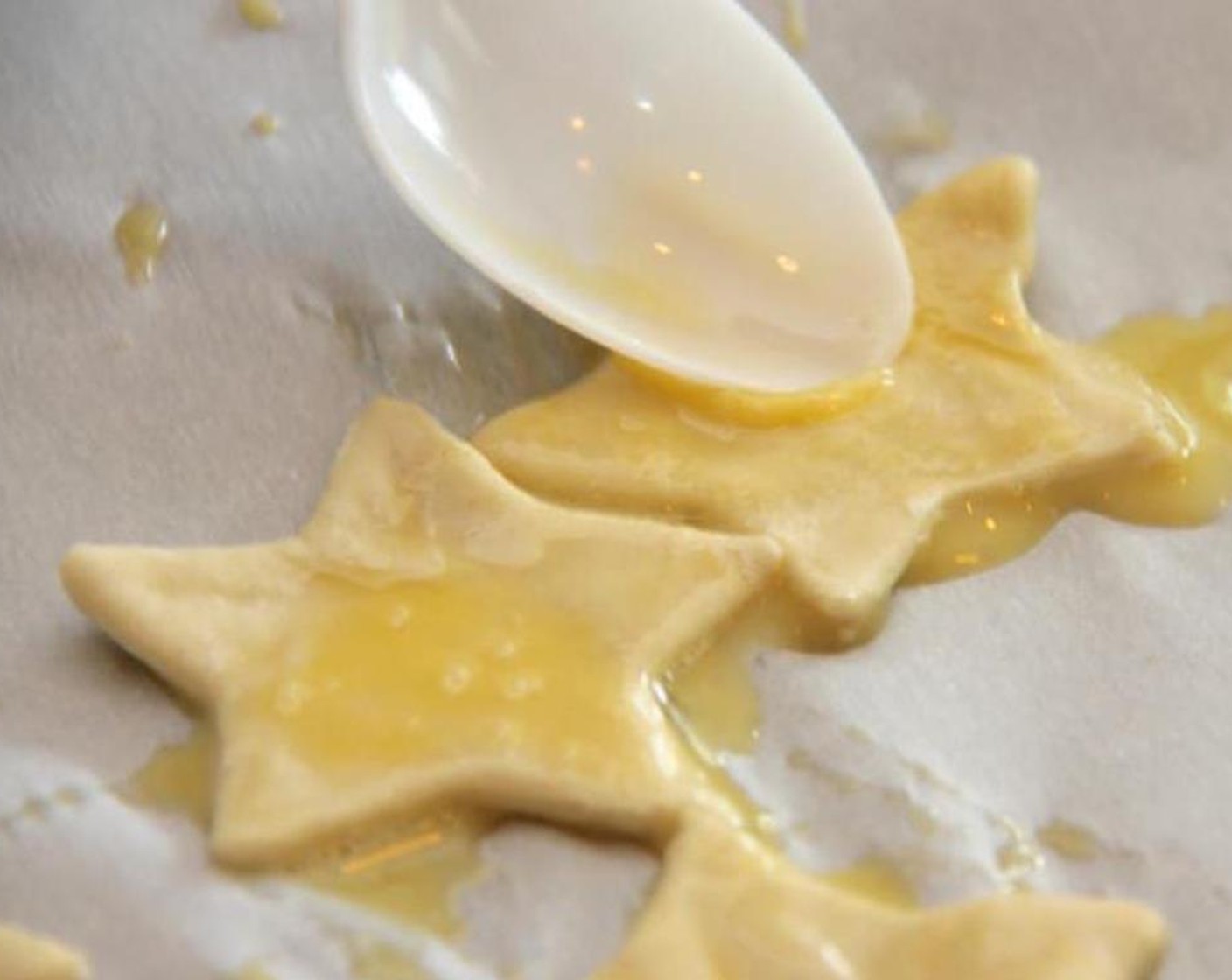 step 4 Lay shapes onto a sheet of parchment paper on your baking pan and brush with egg wash.