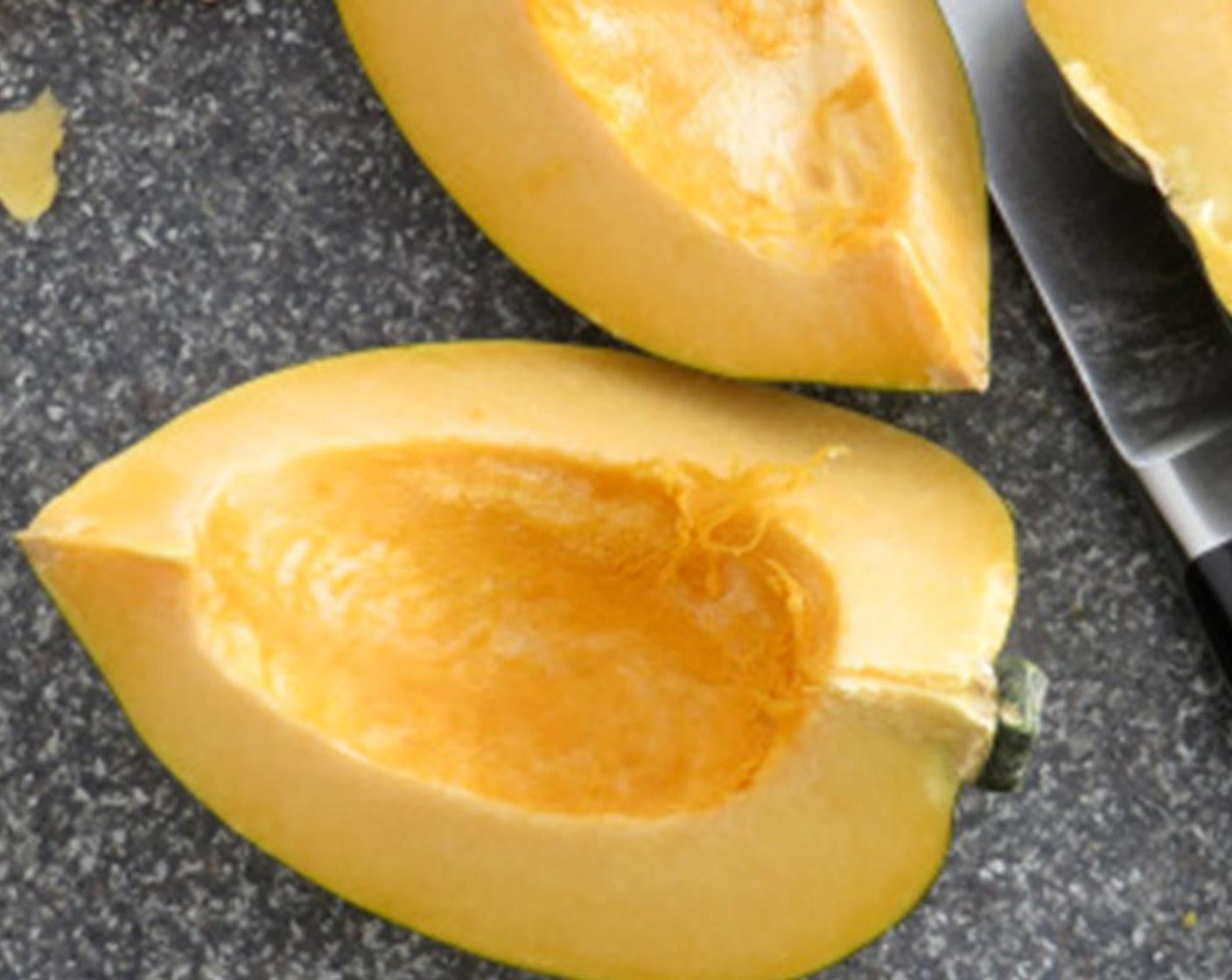 step 4 Cut the Acorn Squash (1) half lengthwise. Scoop out the seeds and discard. Set the cut side down on a cutting board. Halve it again lengthwise. Place on a roasting pan and coat each with Olive Oil (1/2 Tbsp).