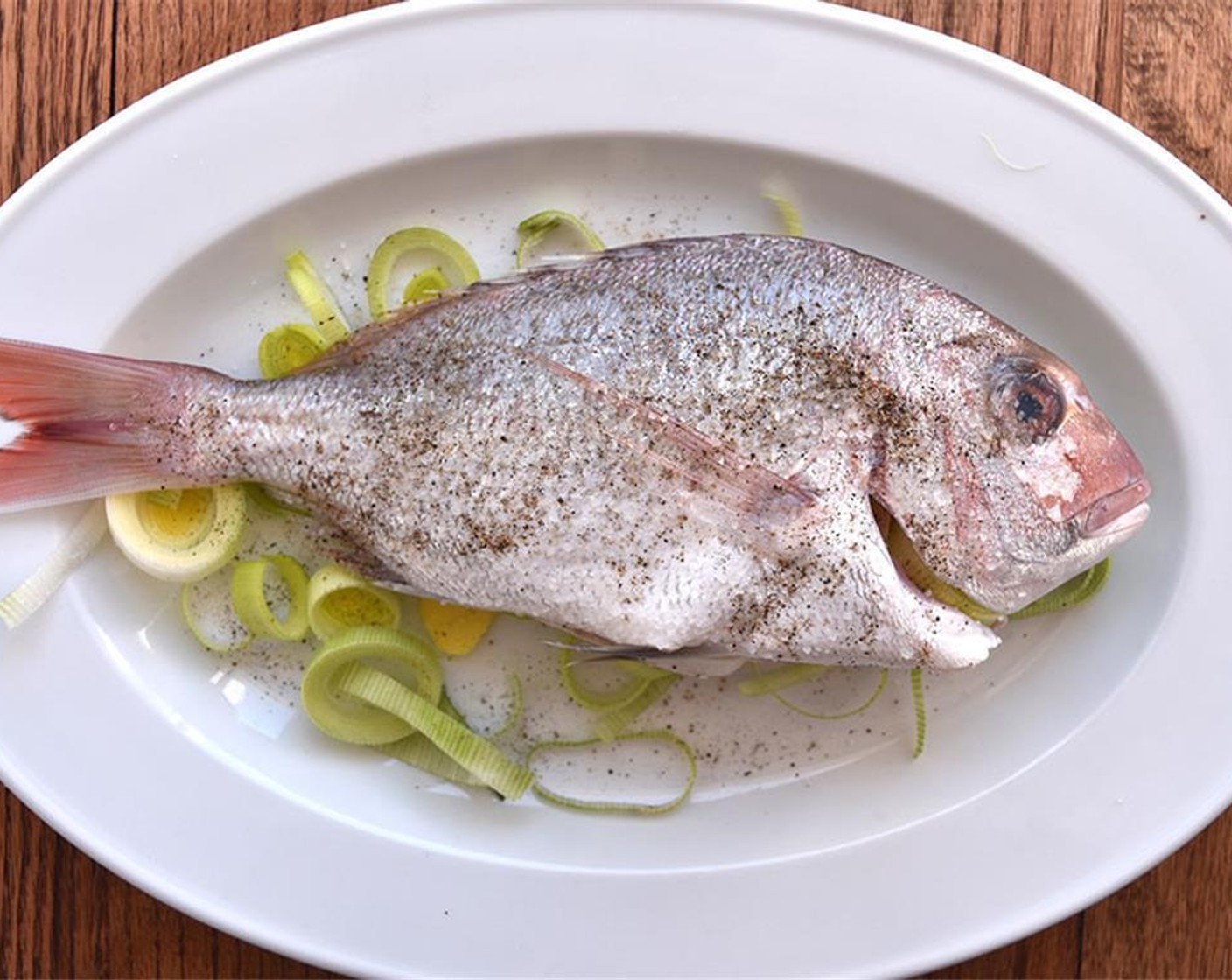 step 3 Rub Whole Fish (1) with Salt (1 Tbsp). Stuff the fish and line the dish with half the ginger and the white/light green part of the leek.