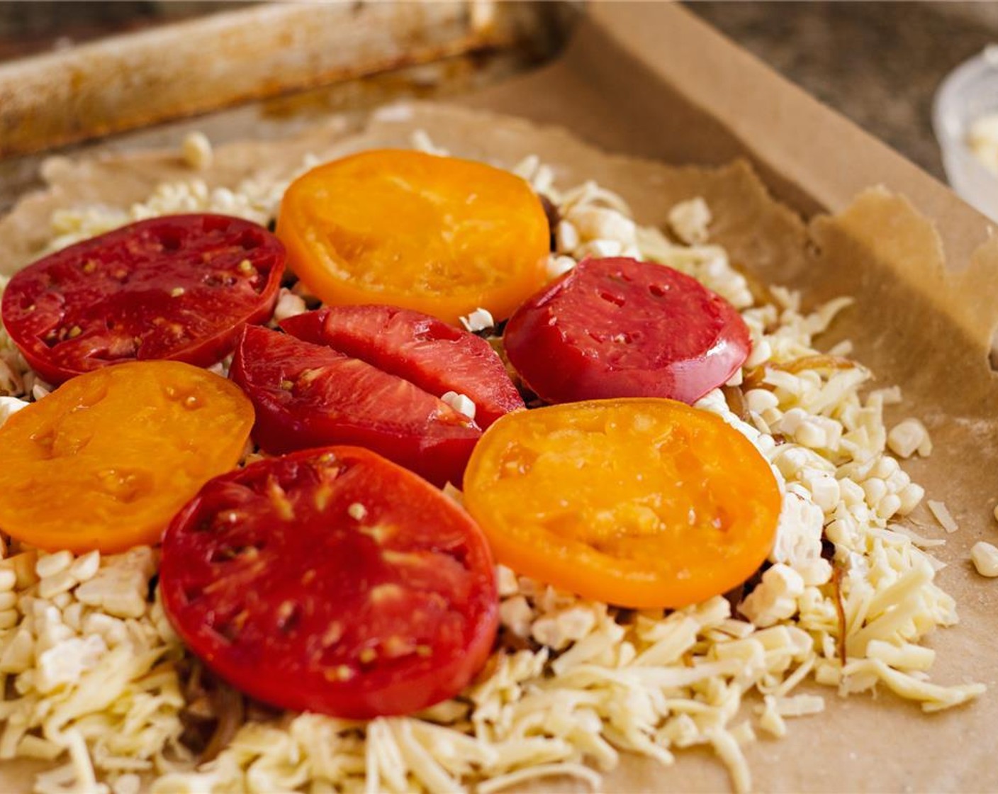 step 13 Arrange the sliced tomatoes on top of the onions. Fold the dough up around the tomatoes.