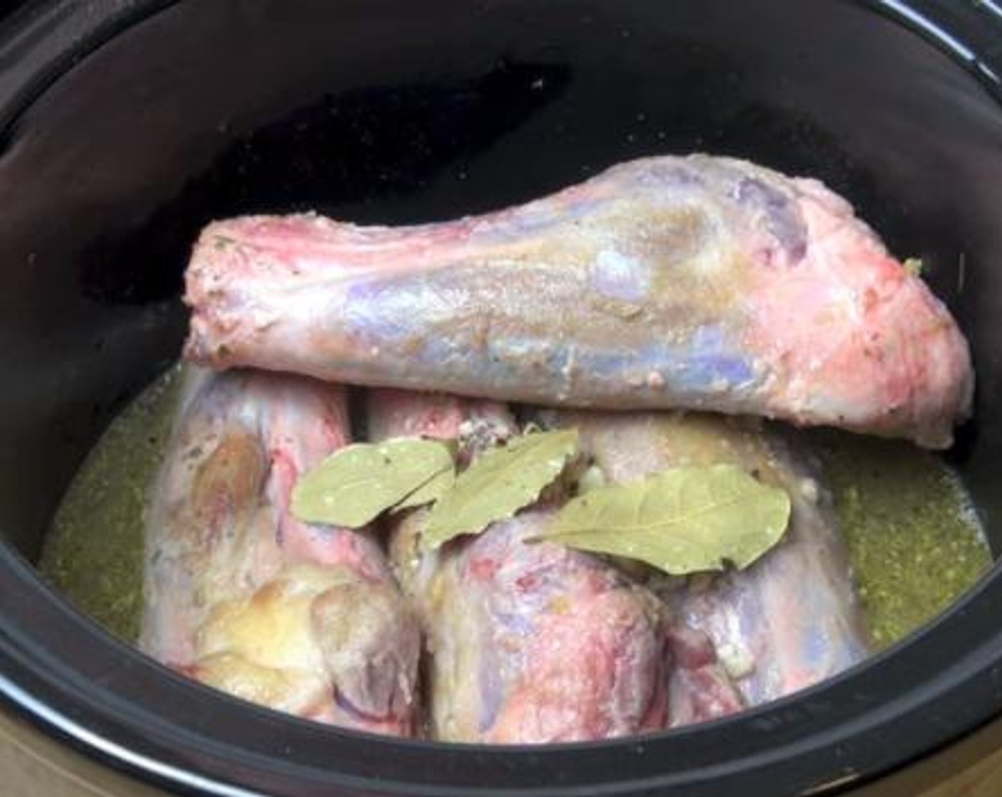 step 4 Put the shanks in a slow cooker, and add in with some Garlic (2 cloves), Bay Leaves (3), Italian Seasoning (to taste), Salt (to taste), and Ground Black Pepper (to taste). Then pour in the chicken stock, and cook for about 8 hours.