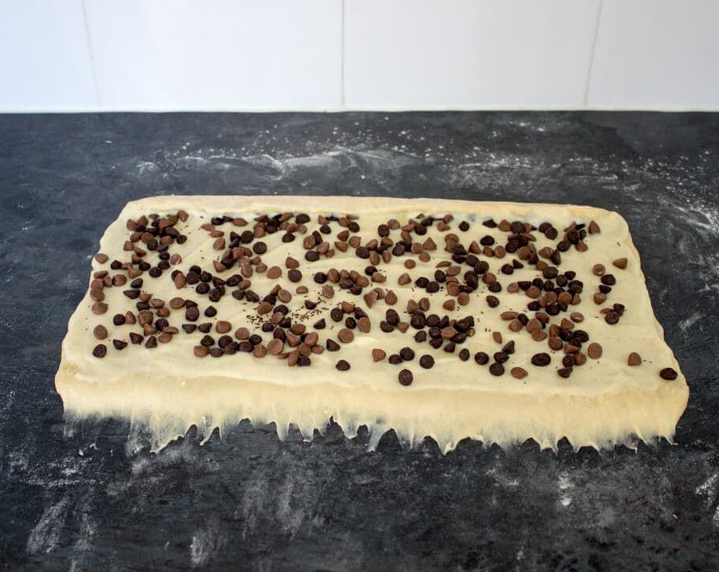 step 22 Evenly sprinkle the Milk Chocolate Chips (3 1/2 Tbsp) and Dark Chocolate Chips (1/4 cup) over the creme patissiere then tack the long edge nearest you to the worktop.