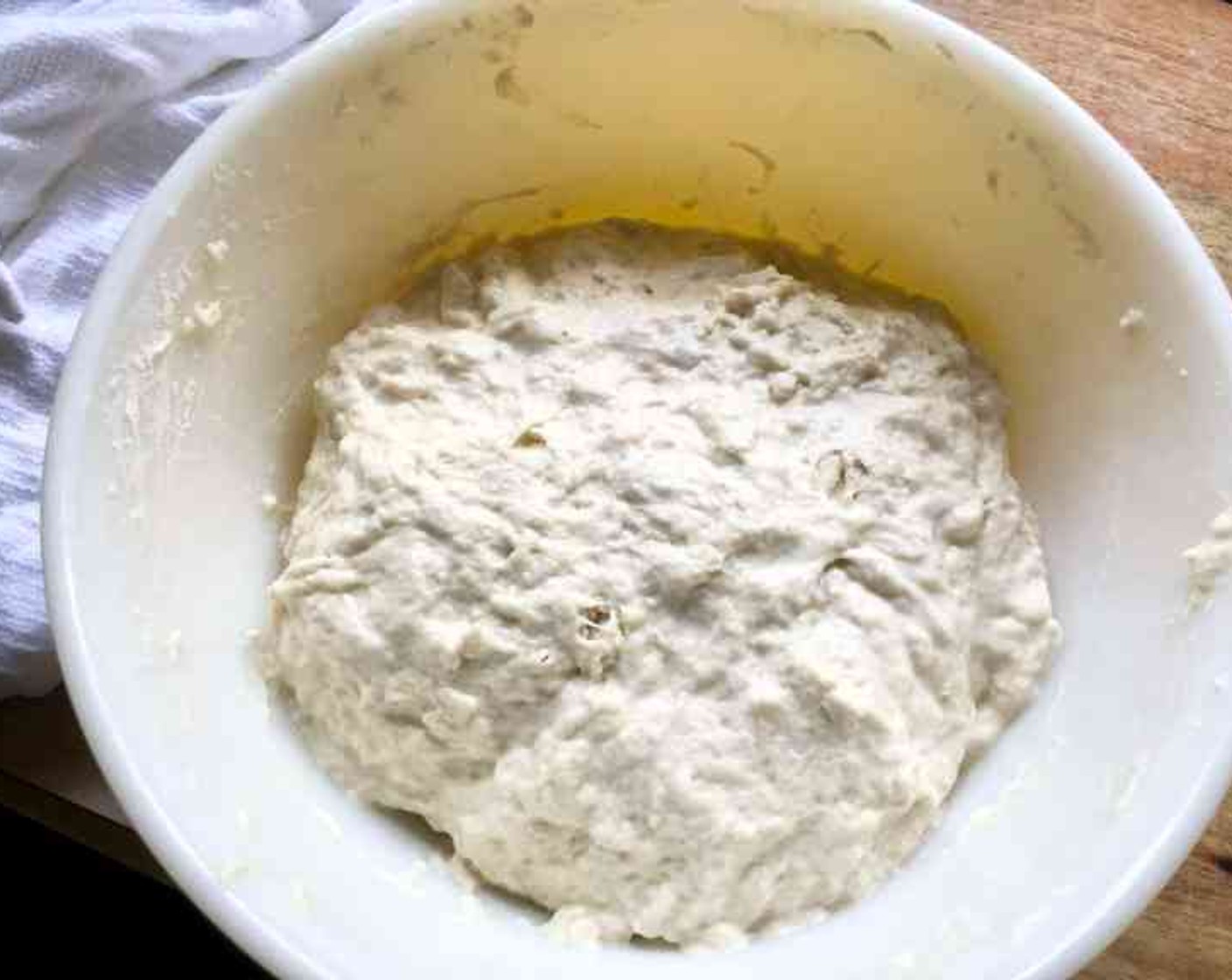 step 2 Cover the bowl with a damp cotton towel or plastic wrap. Set aside in a warm spot to rise for about 1 1/2 hours, until the dough has doubled in volume.