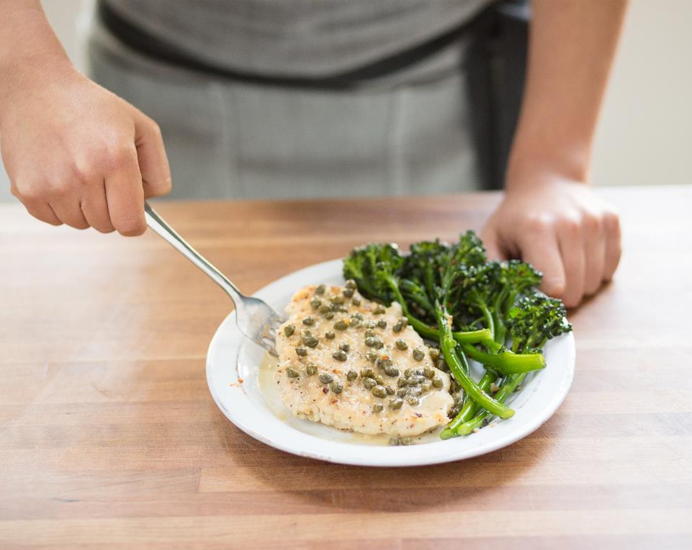 step 15 In the center of two plates, place the broccolini. Place chicken on the side and top with caper sauce. Serve and enjoy!